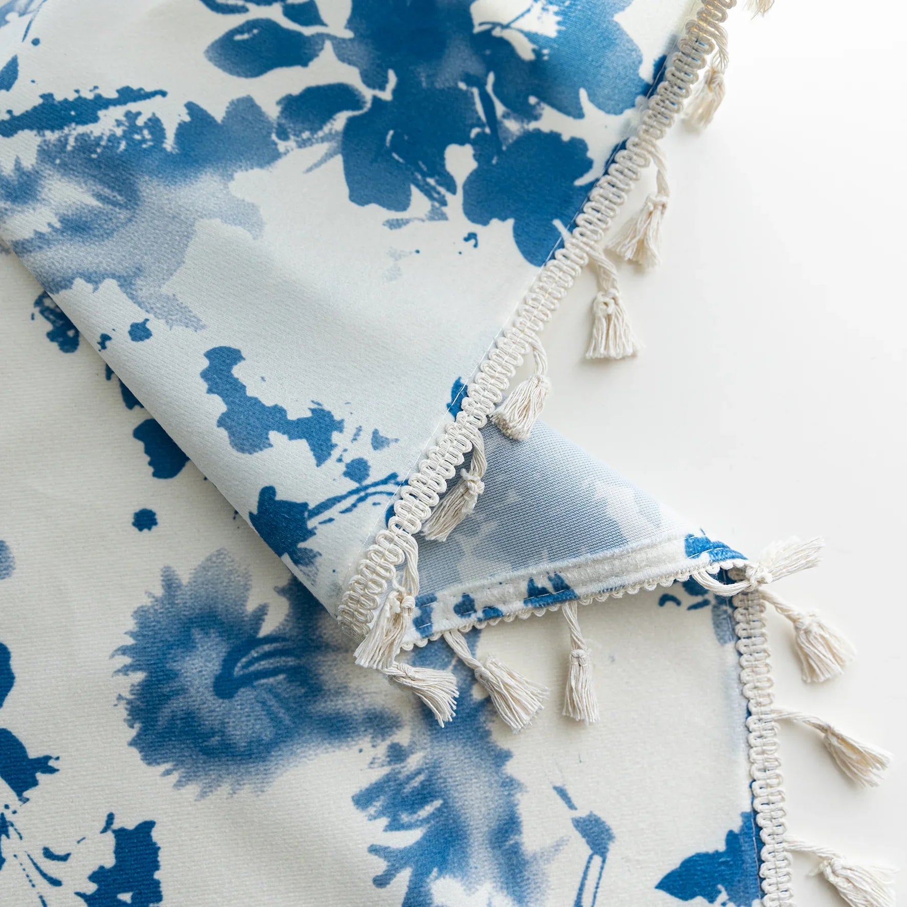 Elegant white curtain with soft watercolor-style blue floral prints, finished with delicate tassel trim — perfect for adding a fresh, airy, and romantic touch to your living room, bedroom, or cozy reading nook.