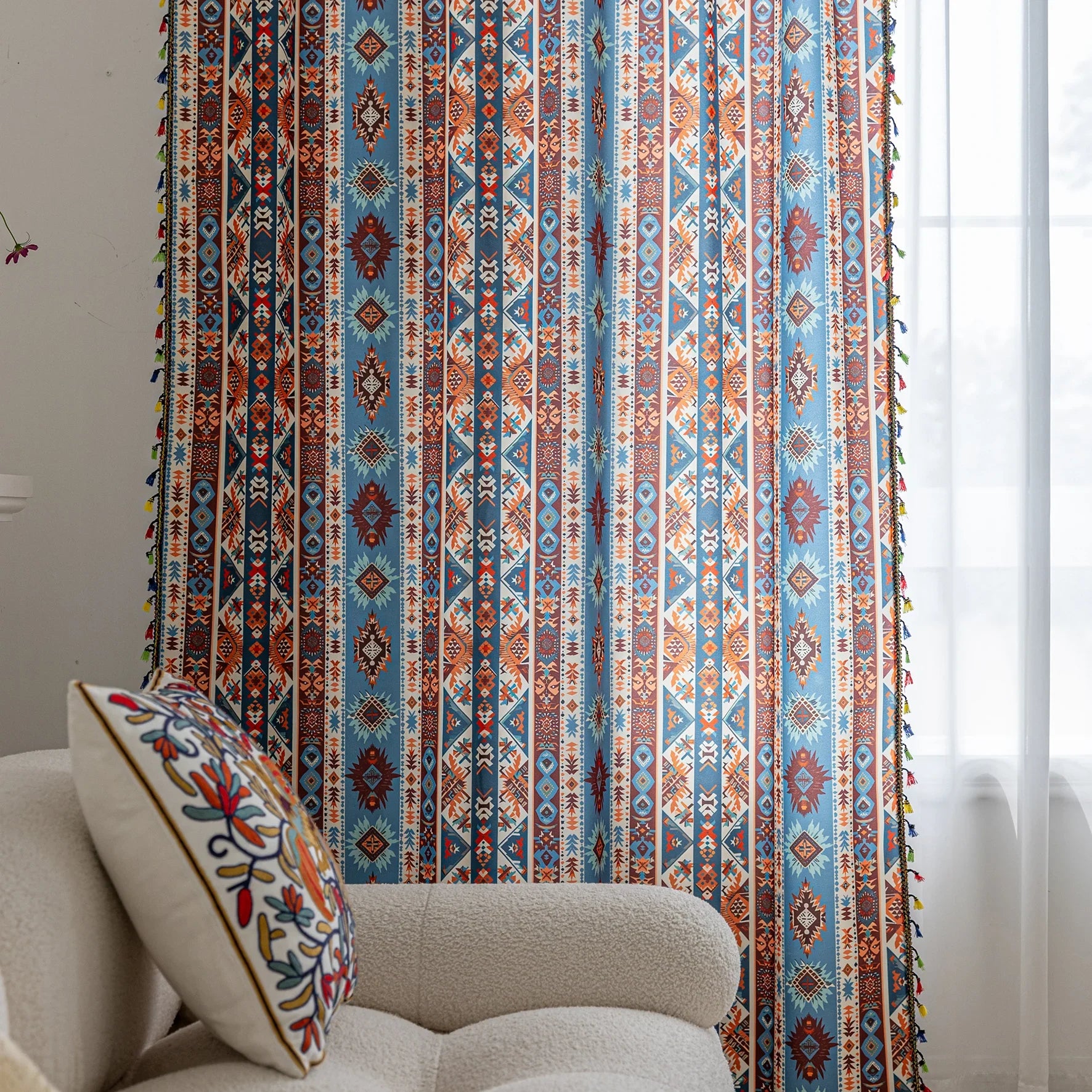 Vibrant bohemian curtain with a striking tribal geometric pattern in earthy rust, deep blue, and cream tones, accented with colorful tassel trim — perfect for adding warmth, character, and a Southwestern-inspired charm to any room.