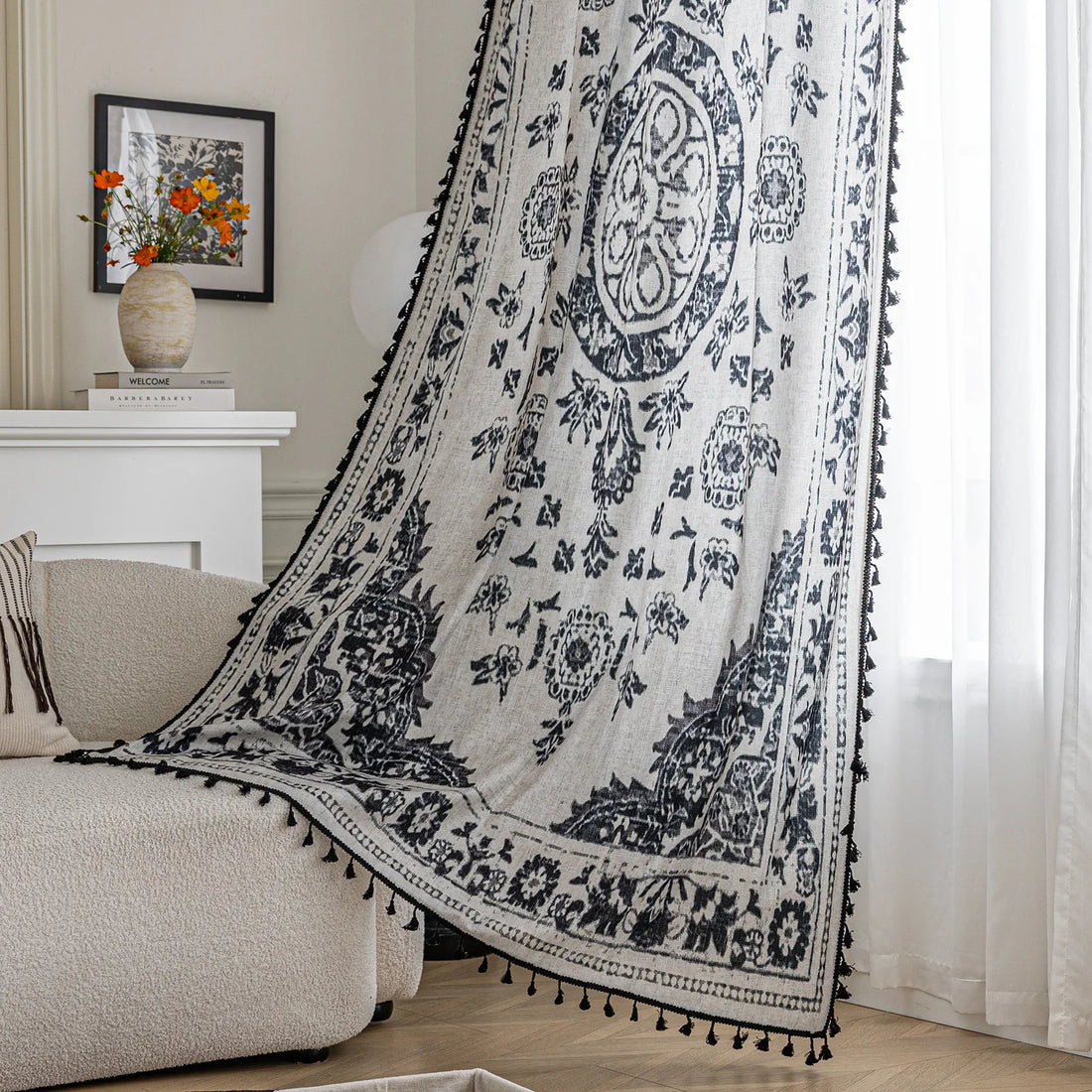 Elegant bohemian curtain in soft beige with intricate black floral and medallion motifs, finished with delicate black tassel trim — perfect for adding vintage charm and artistic flair to living rooms, bedrooms, or creative spaces.