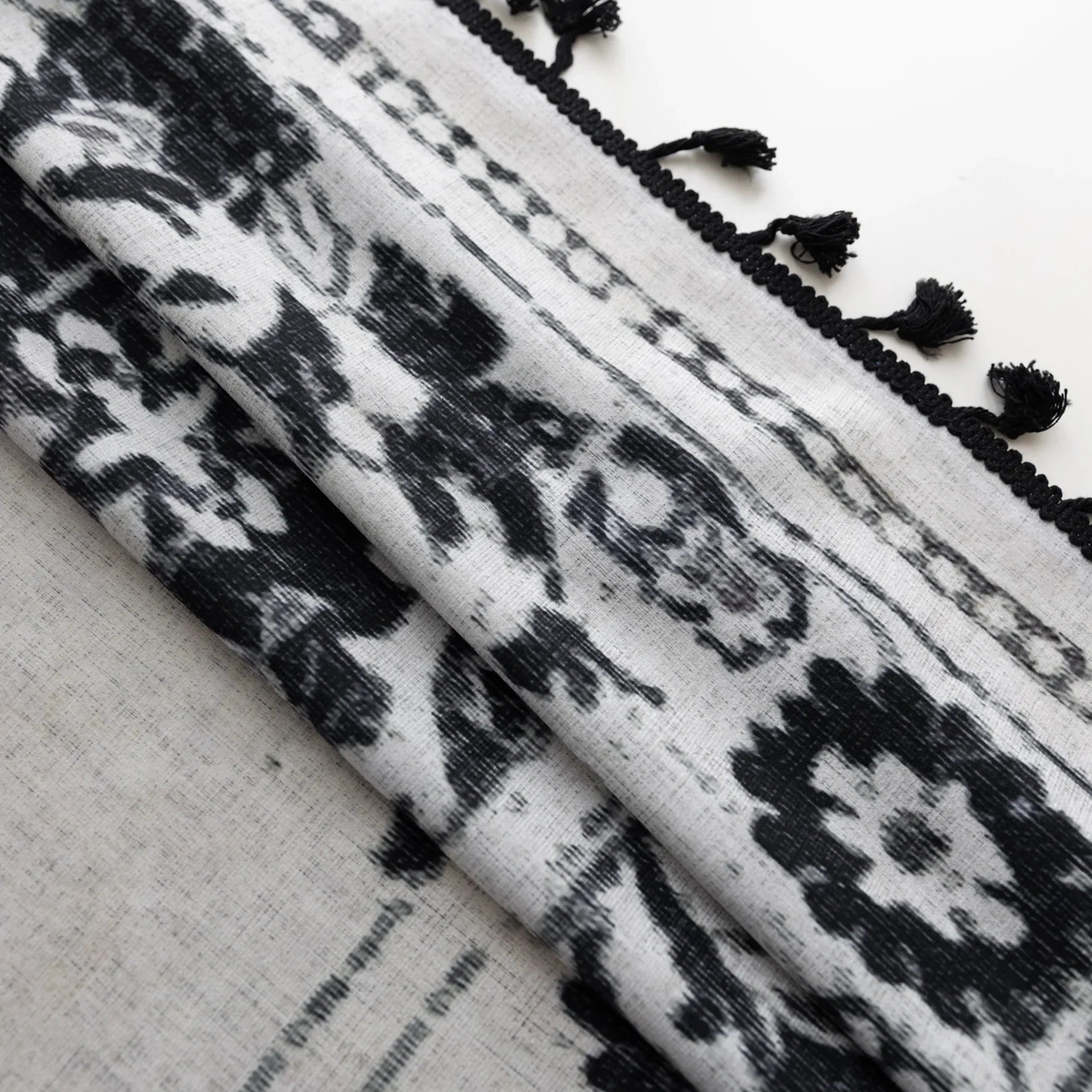 Elegant bohemian curtain in soft beige with intricate black floral and medallion motifs, finished with delicate black tassel trim — perfect for adding vintage charm and artistic flair to living rooms, bedrooms, or creative spaces.