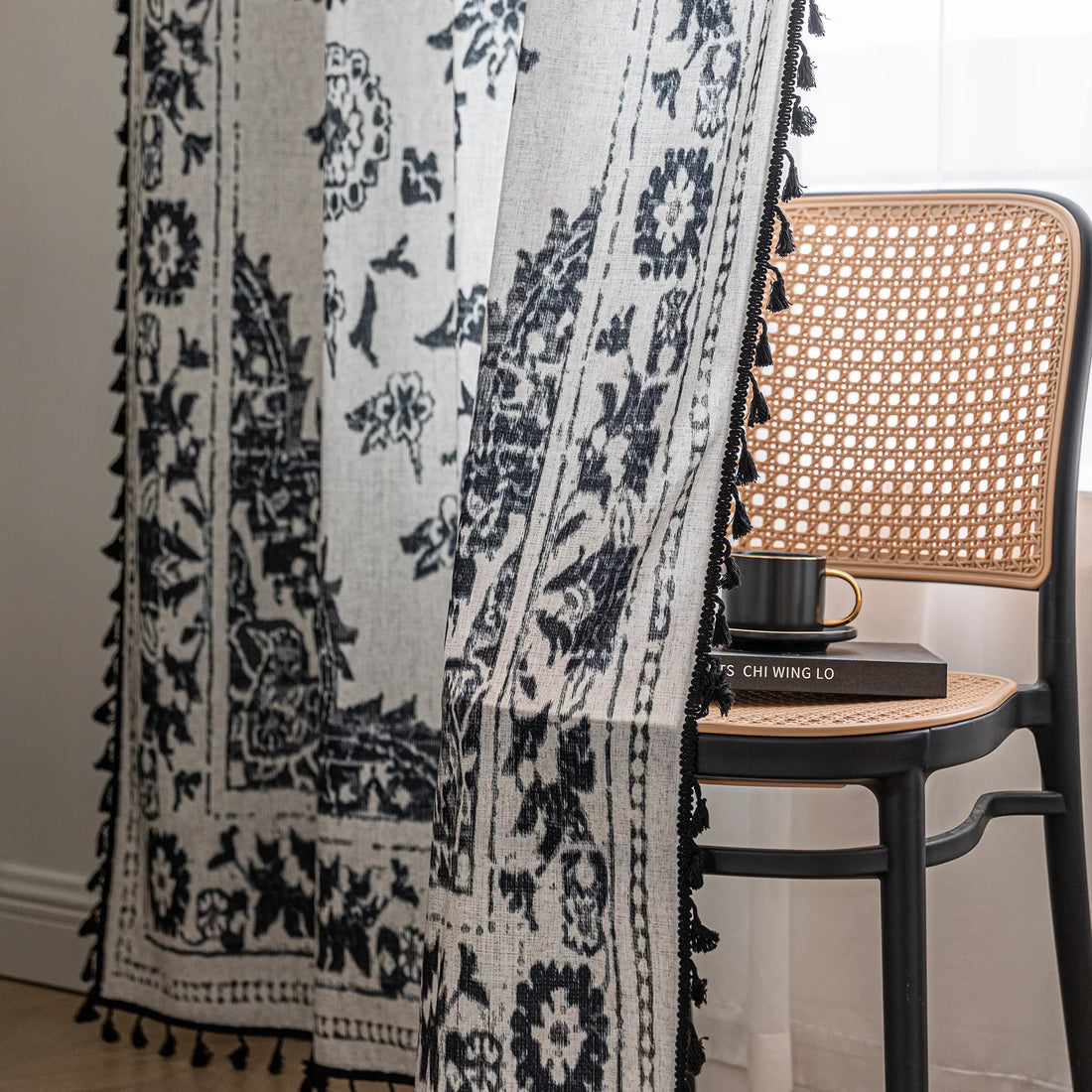 Elegant bohemian curtain in soft beige with intricate black floral and medallion motifs, finished with delicate black tassel trim — perfect for adding vintage charm and artistic flair to living rooms, bedrooms, or creative spaces.