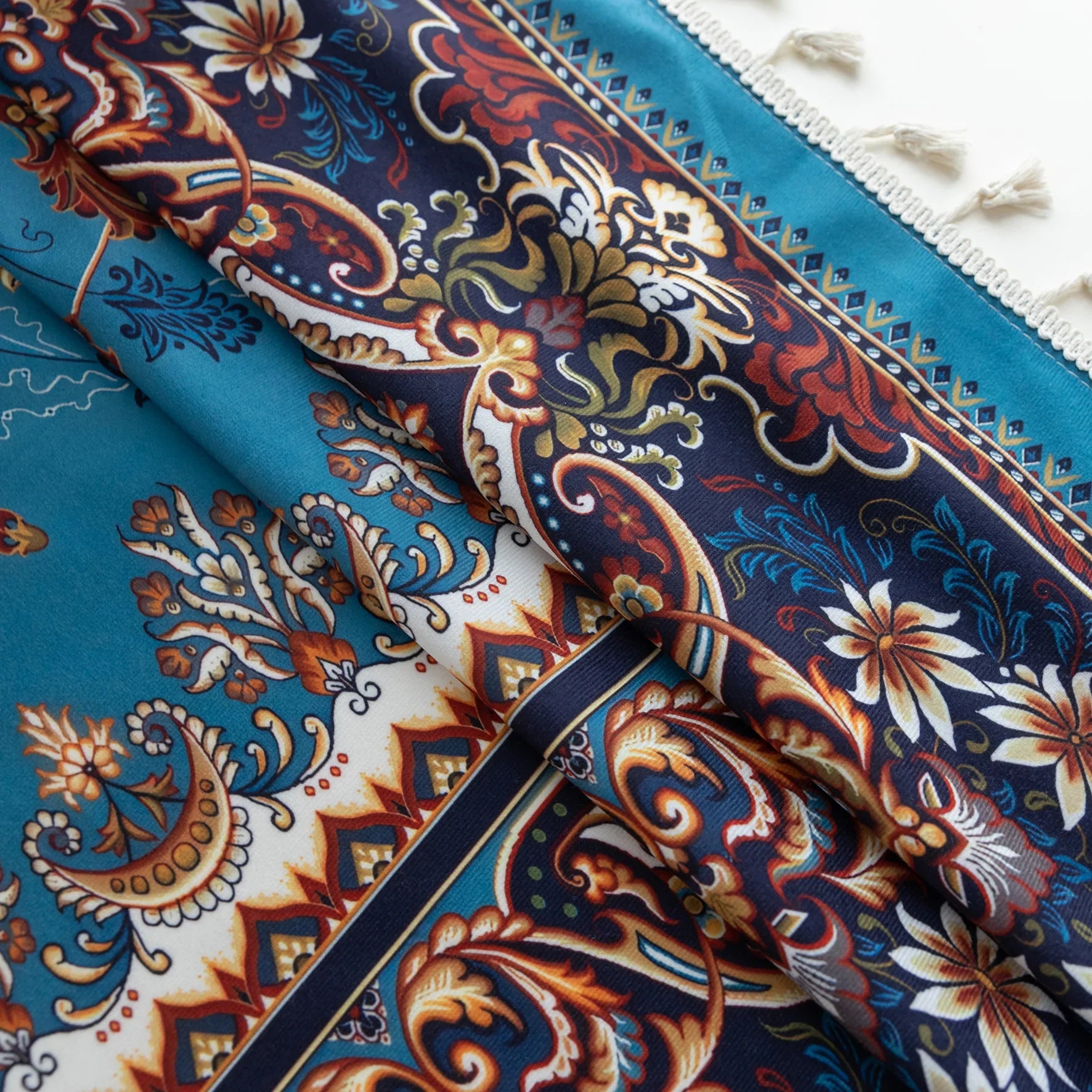 Luxurious curtain with a rich turquoise base, adorned with intricate floral and paisley patterns in warm earthy tones, framed by an ornate contrasting border — ideal for adding elegance and cultural charm to any room.