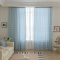 Sky blue curtain with a delicate white grid pattern and tassel trim — a stylish and airy window treatment that brightens your space while adding a modern, cozy touch.