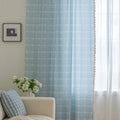 Sky blue curtain with a delicate white grid pattern and tassel trim — a stylish and airy window treatment that brightens your space while adding a modern, cozy touch.