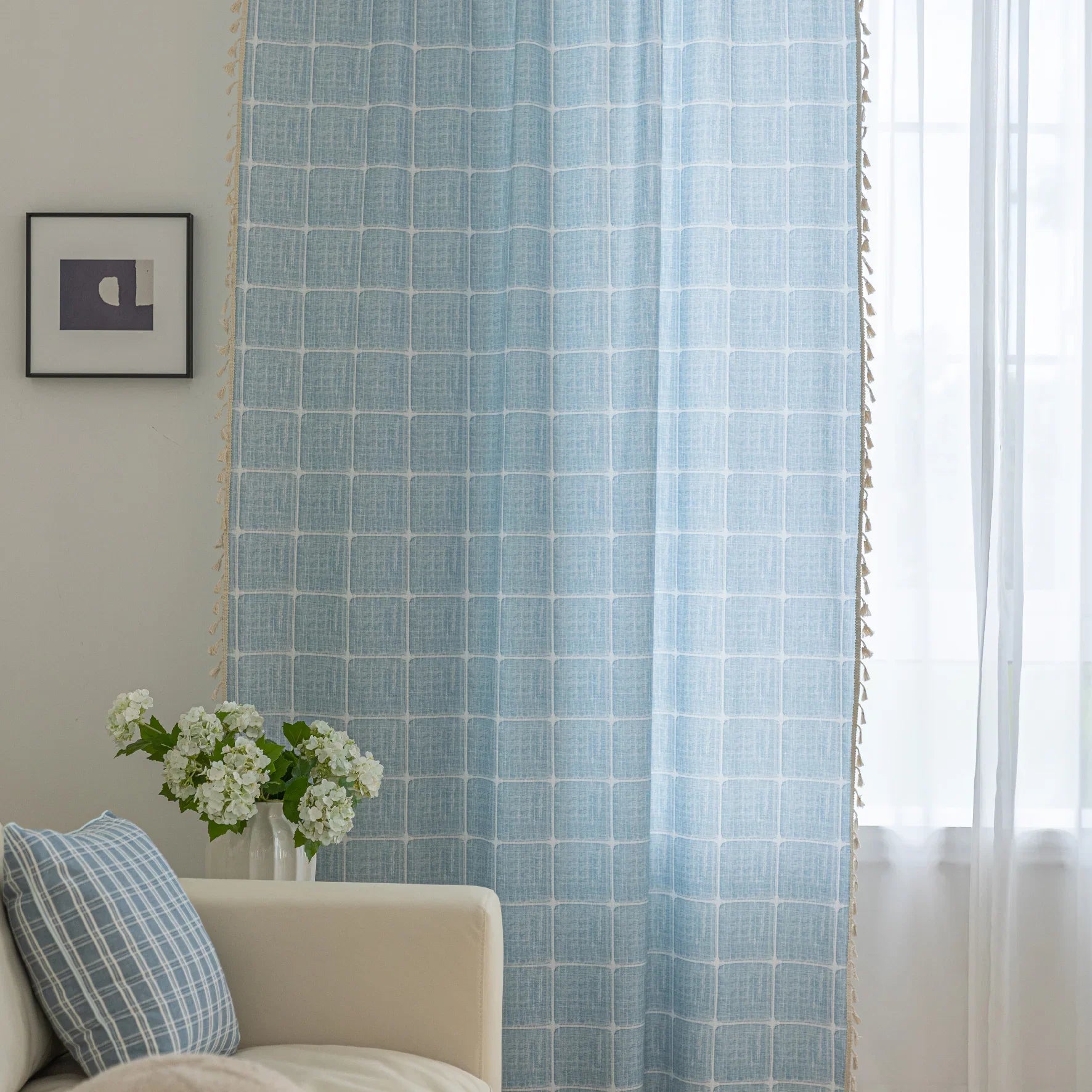 Sky blue curtain with a delicate white grid pattern and tassel trim — a stylish and airy window treatment that brightens your space while adding a modern, cozy touch.