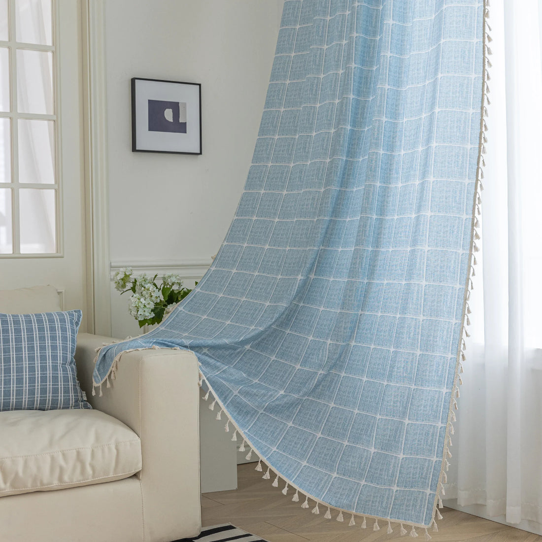 Sky blue curtain with a delicate white grid pattern and tassel trim — a stylish and airy window treatment that brightens your space while adding a modern, cozy touch.