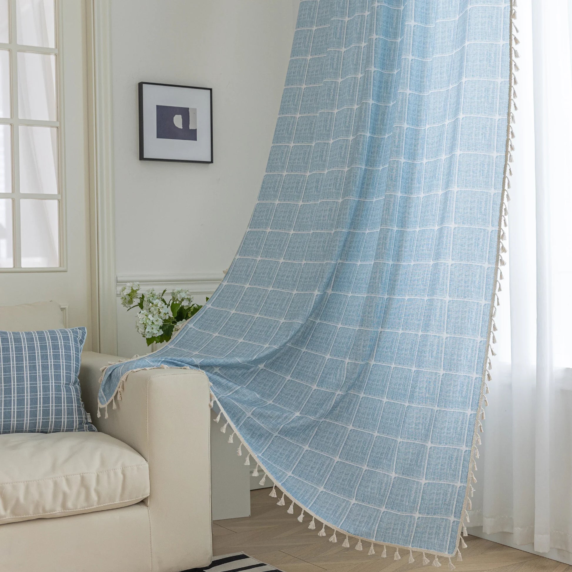 Sky blue curtain with a delicate white grid pattern and tassel trim — a stylish and airy window treatment that brightens your space while adding a modern, cozy touch.