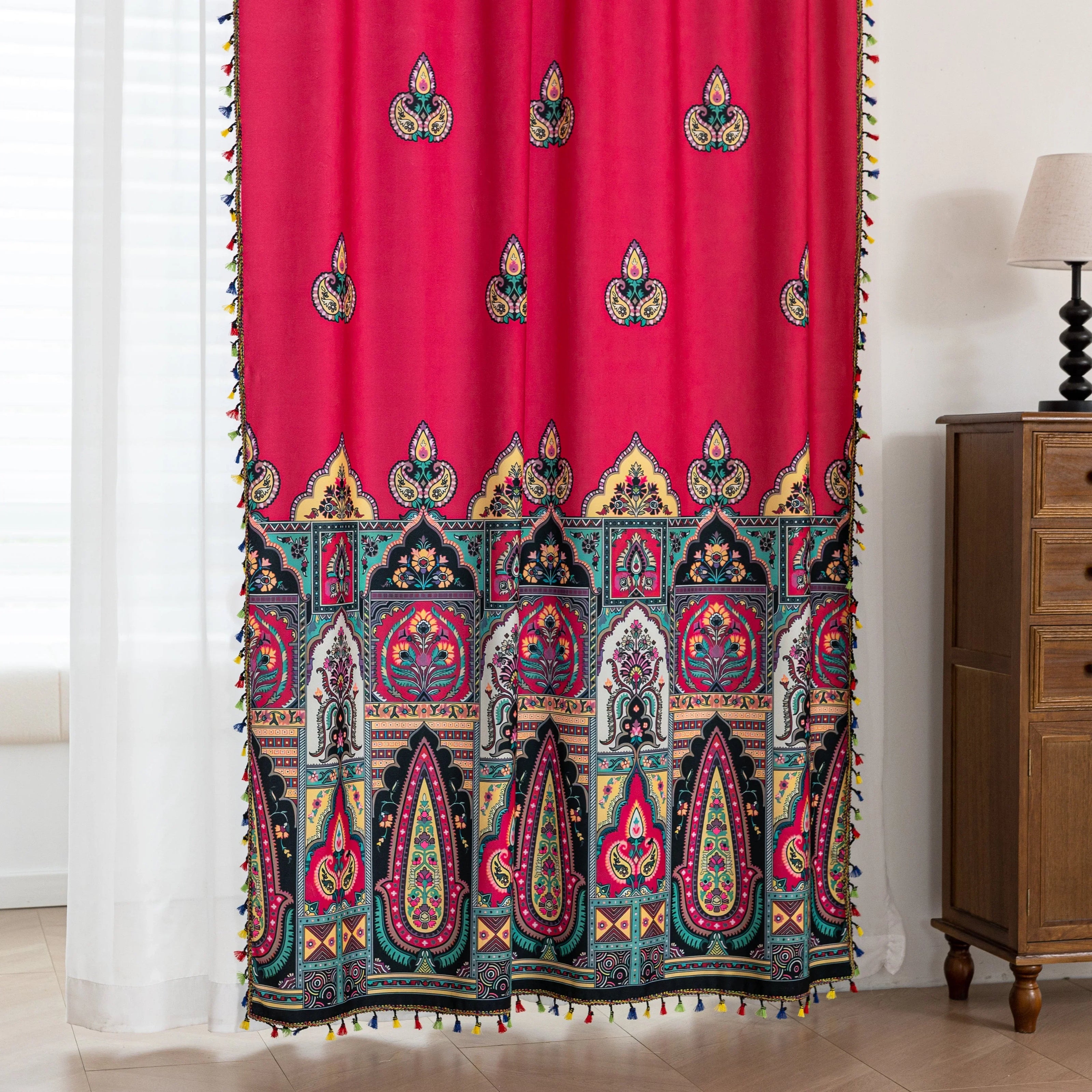 Vibrant Red Bohemian Curtains ¨C Infuse your home with bold color and artistic flair using these stunning red curtains adorned with intricate multicolor ethnic patterns. The rich crimson backdrop is complemented by an elaborate border design in green, gold, and black, with small paisley-style motifs scattered throughout. Crafted from lightweight fabric, they softly filter sunlight while adding a warm, inviting atmosphere to any room. Perfect for living rooms, bedrooms, or creative spaces, these tassel-trimm