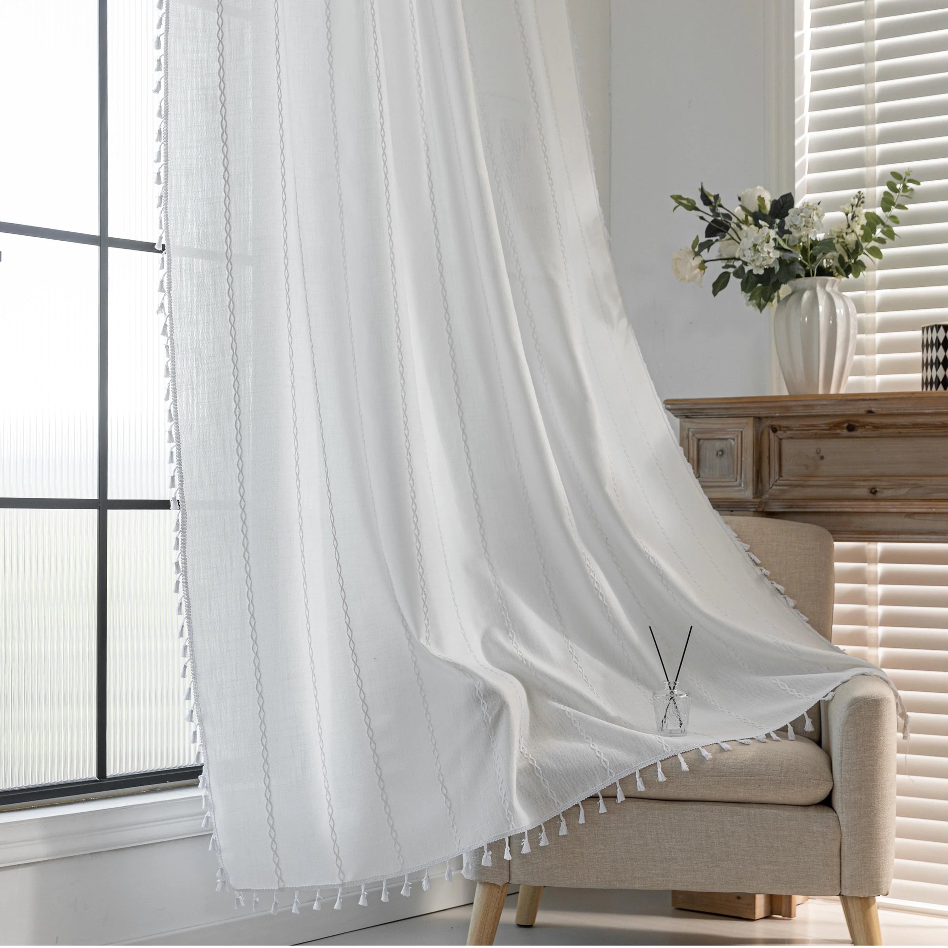 Elegant White Tassel Curtains – Bring timeless charm and brightness to your home with these beautiful white curtains, featuring subtle vertical embroidery and delicate tassel trim. Crafted from soft, airy fabric, they allow natural light to flow in while preserving your privacy. Perfect for living rooms, bedrooms, or dining spaces, their clean, versatile design complements modern, minimalist, coastal, or bohemian décor styles. Durable, easy to maintain, and effortlessly stylish, these curtains add a fresh a