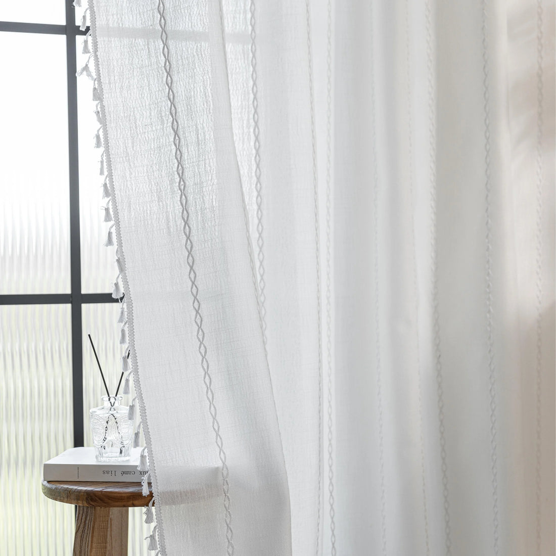 Elegant White Tassel Curtains – Bring timeless charm and brightness to your home with these beautiful white curtains, featuring subtle vertical embroidery and delicate tassel trim. Crafted from soft, airy fabric, they allow natural light to flow in while preserving your privacy. Perfect for living rooms, bedrooms, or dining spaces, their clean, versatile design complements modern, minimalist, coastal, or bohemian décor styles. Durable, easy to maintain, and effortlessly stylish, these curtains add a fresh a