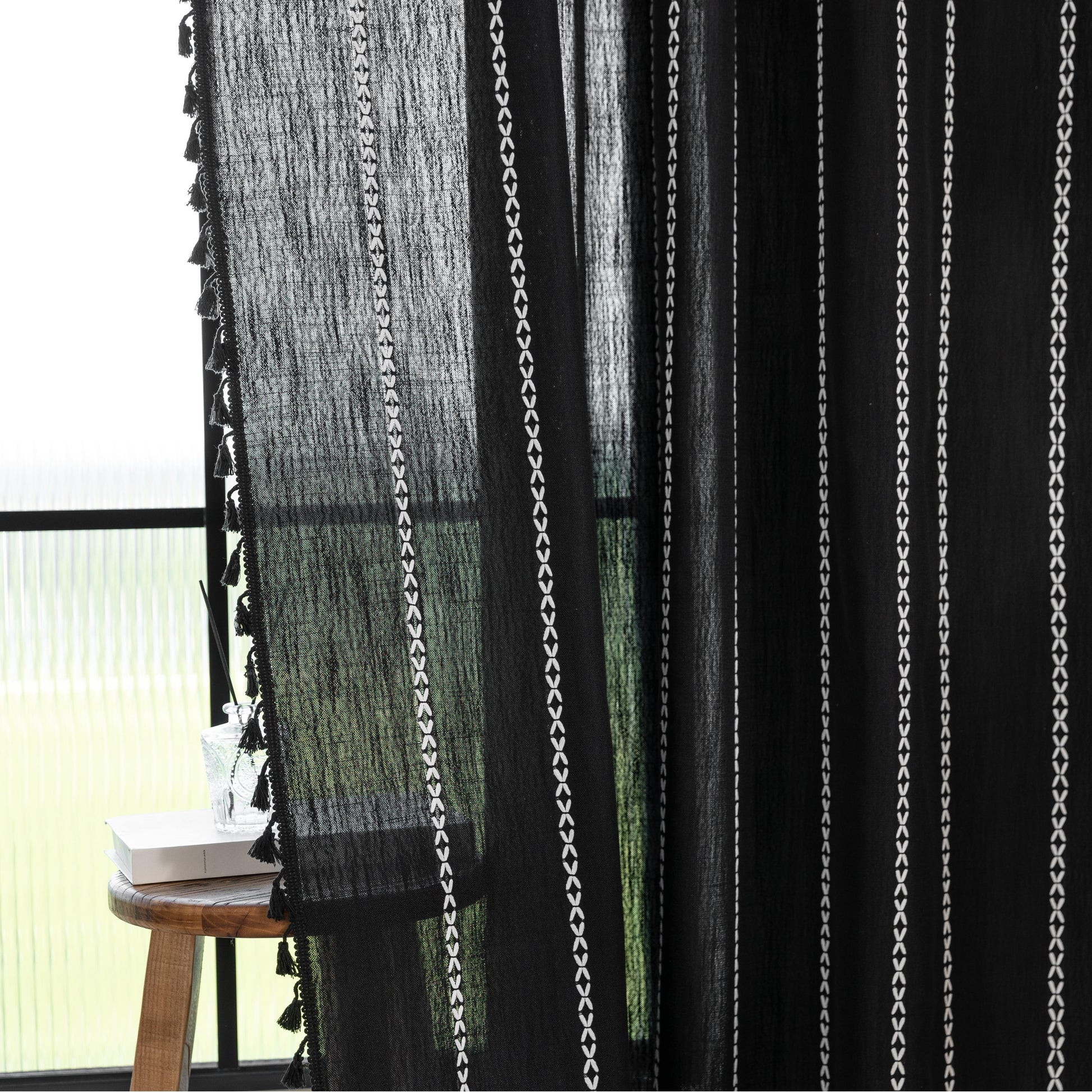 Elegant Black Tassel Curtains – Add a touch of sophistication to your home with these stylish black curtains featuring delicate vertical white embroidery and playful tassel trim. Crafted from lightweight, breathable fabric, they provide a perfect balance of privacy and natural light, making them ideal for living rooms, bedrooms, or reading nooks. The timeless black-and-white design complements modern, bohemian, and contemporary interiors, while the tassel detailing adds a chic, artisanal flair. Durable and 
