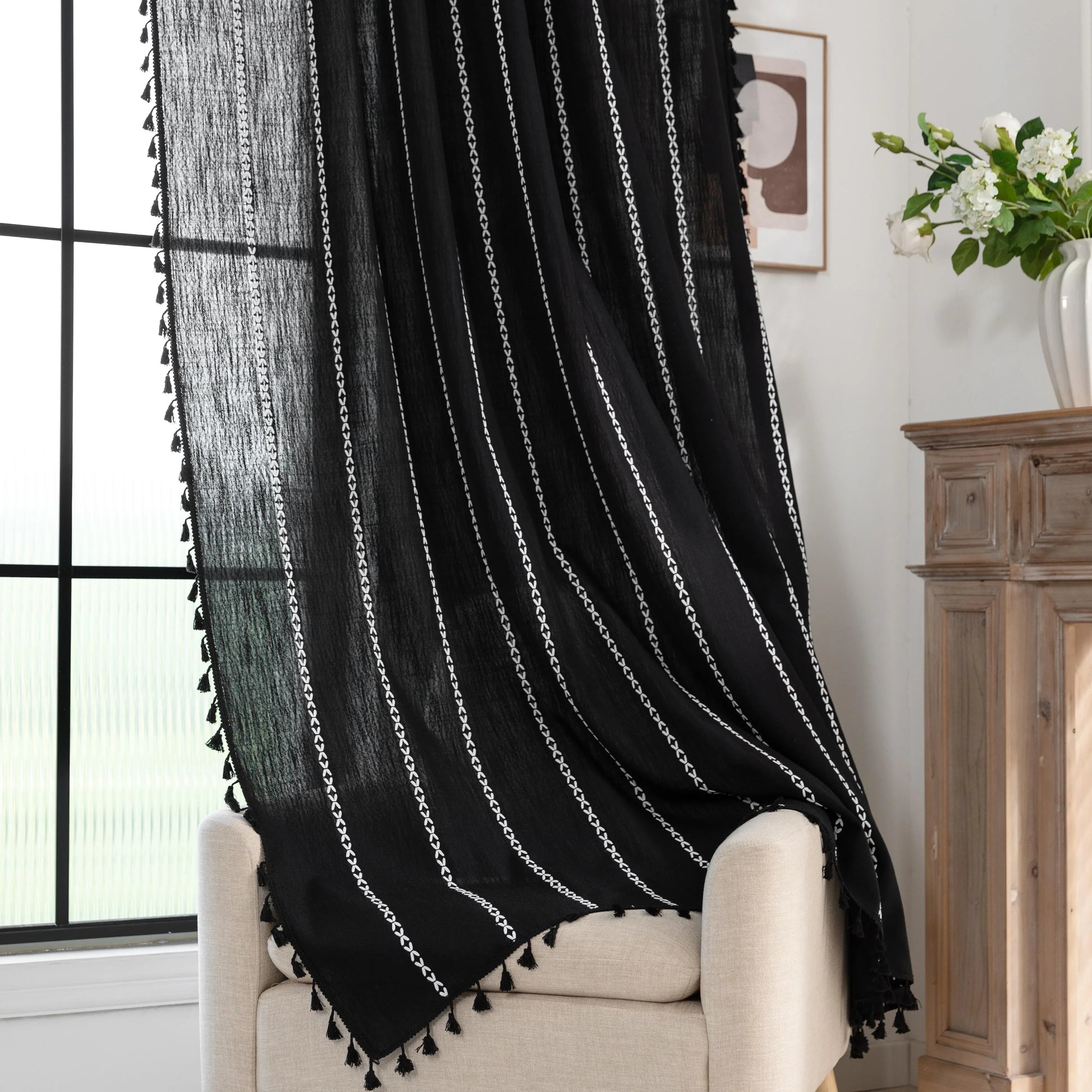 Elegant Black Tassel Curtains – Add a touch of sophistication to your home with these stylish black curtains featuring delicate vertical white embroidery and playful tassel trim. Crafted from lightweight, breathable fabric, they provide a perfect balance of privacy and natural light, making them ideal for living rooms, bedrooms, or reading nooks. The timeless black-and-white design complements modern, bohemian, and contemporary interiors, while the tassel detailing adds a chic, artisanal flair. Durable and 