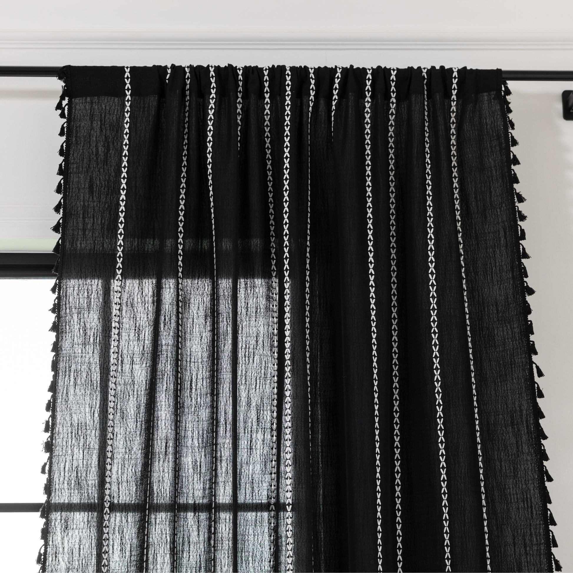 Elegant Black Tassel Curtains – Add a touch of sophistication to your home with these stylish black curtains featuring delicate vertical white embroidery and playful tassel trim. Crafted from lightweight, breathable fabric, they provide a perfect balance of privacy and natural light, making them ideal for living rooms, bedrooms, or reading nooks. The timeless black-and-white design complements modern, bohemian, and contemporary interiors, while the tassel detailing adds a chic, artisanal flair. Durable and 