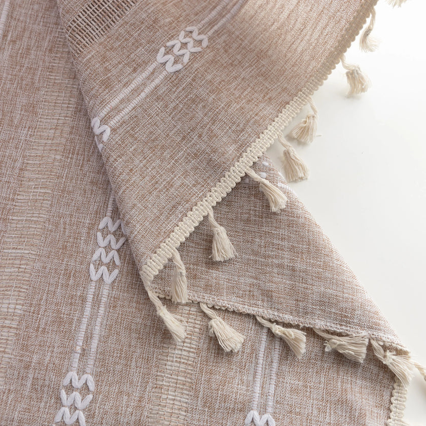 Khaki and white embroidered curtain in a living space