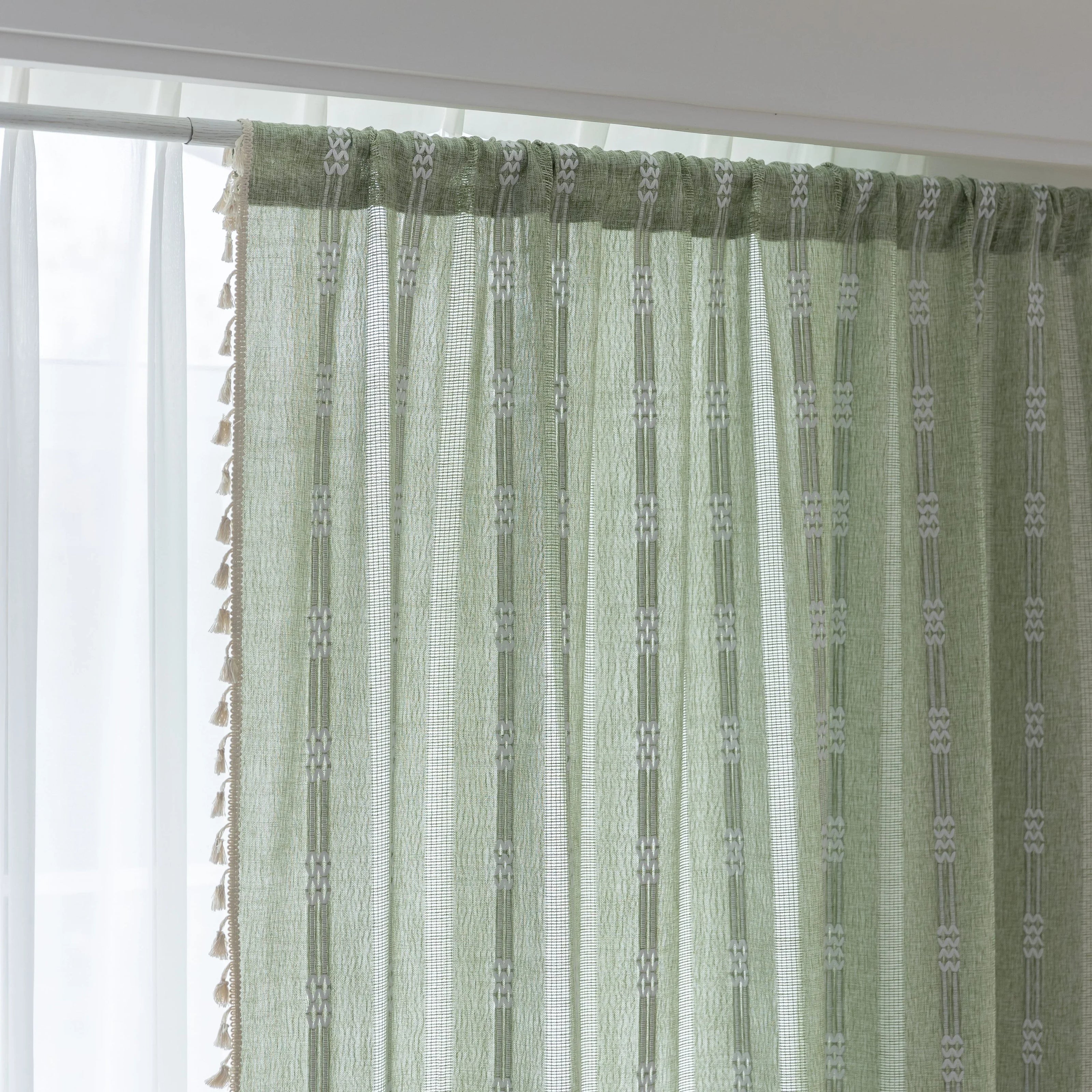 Soft green curtain with delicate vertical white embroidery and tassel trim ¡ª an airy and stylish window treatment ideal for creating a light, refreshing, and cozy atmosphere in any room.