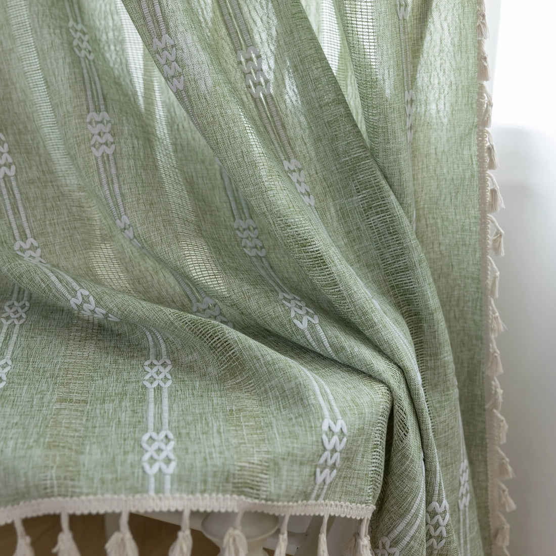 Soft green curtain with delicate vertical white embroidery and tassel trim — an airy and stylish window treatment ideal for creating a light, refreshing, and cozy atmosphere in any room.