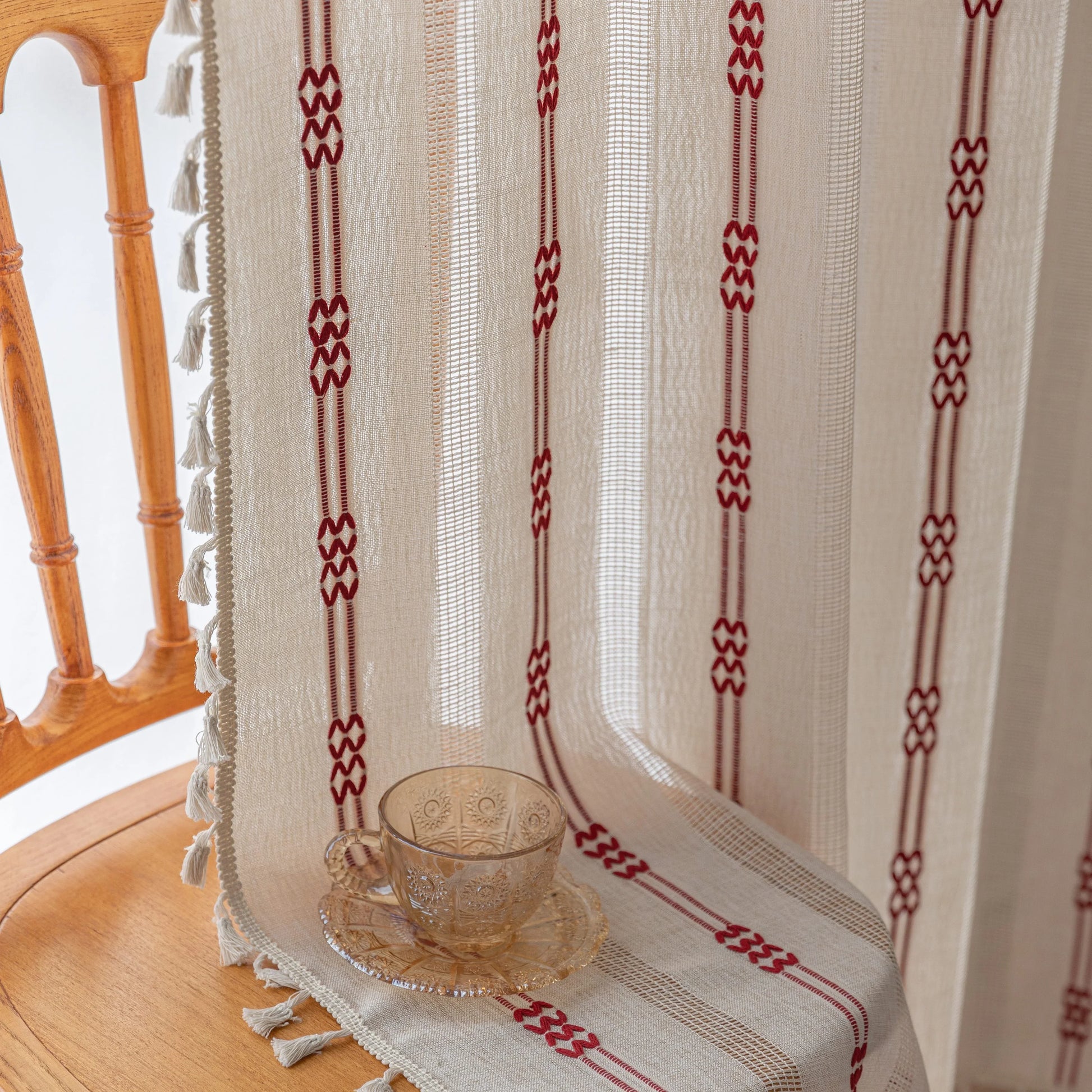 Elegant white curtain with vertical red embroidered stripes and subtle tassel edging — perfect for adding a touch of sophistication and warmth to your living room or bedroom décor.