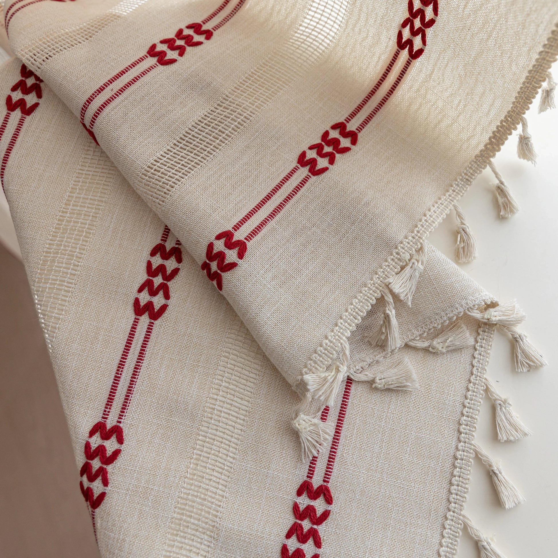 Elegant white curtain with vertical red embroidered stripes and subtle tassel edging — perfect for adding a touch of sophistication and warmth to your living room or bedroom décor.