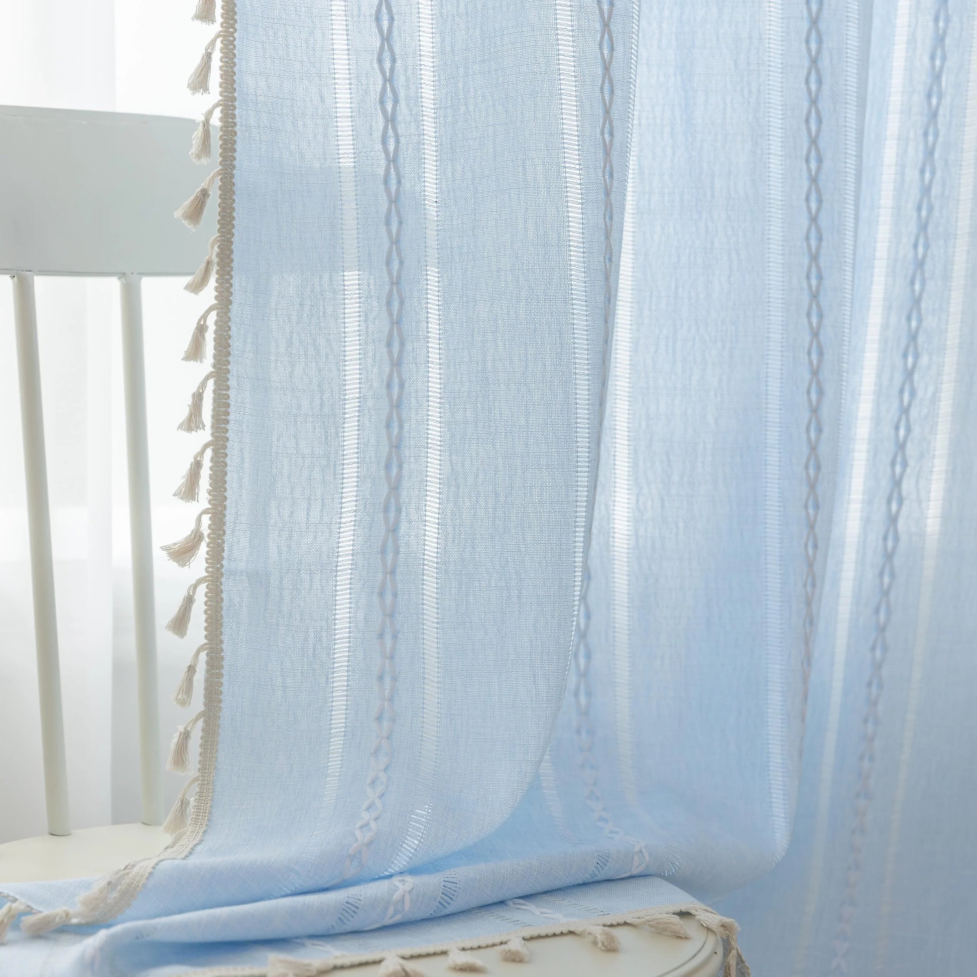 Light Blue Sheer Tassel Curtains – Bring a refreshing, airy charm to your home with these elegant light blue curtains, designed with delicate vertical weave patterns for subtle texture and style. The lightweight, semi-sheer fabric allows natural light to filter through while providing a soft layer of privacy. Finished with playful tassel edges, these curtains add a touch of coastal, bohemian, or contemporary elegance to any living room, bedroom, or dining area. Perfect for creating a serene and inviting atm