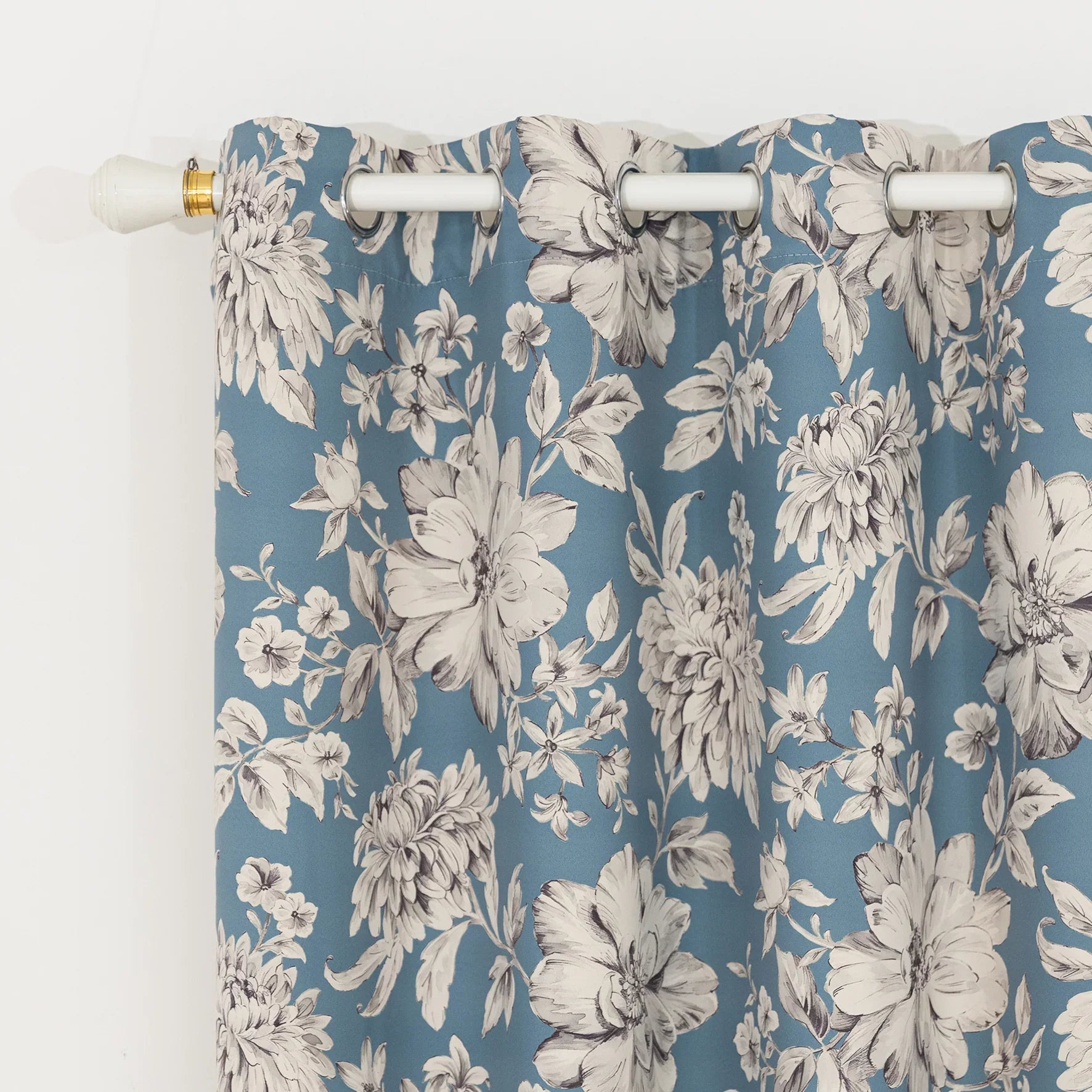 Elegant floral blackout curtain featuring soft cream blossoms on a serene blue background, combining classic botanical charm with effective light-blocking for a cozy and stylish living space.