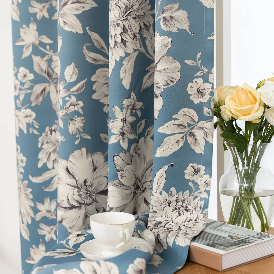 Elegant floral blackout curtain featuring soft cream blossoms on a serene blue background, combining classic botanical charm with effective light-blocking for a cozy and stylish living space.