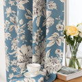 Elegant floral blackout curtain featuring soft cream blossoms on a serene blue background, combining classic botanical charm with effective light-blocking for a cozy and stylish living space.