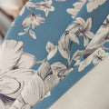 Elegant floral blackout curtain featuring soft cream blossoms on a serene blue background, combining classic botanical charm with effective light-blocking for a cozy and stylish living space.
