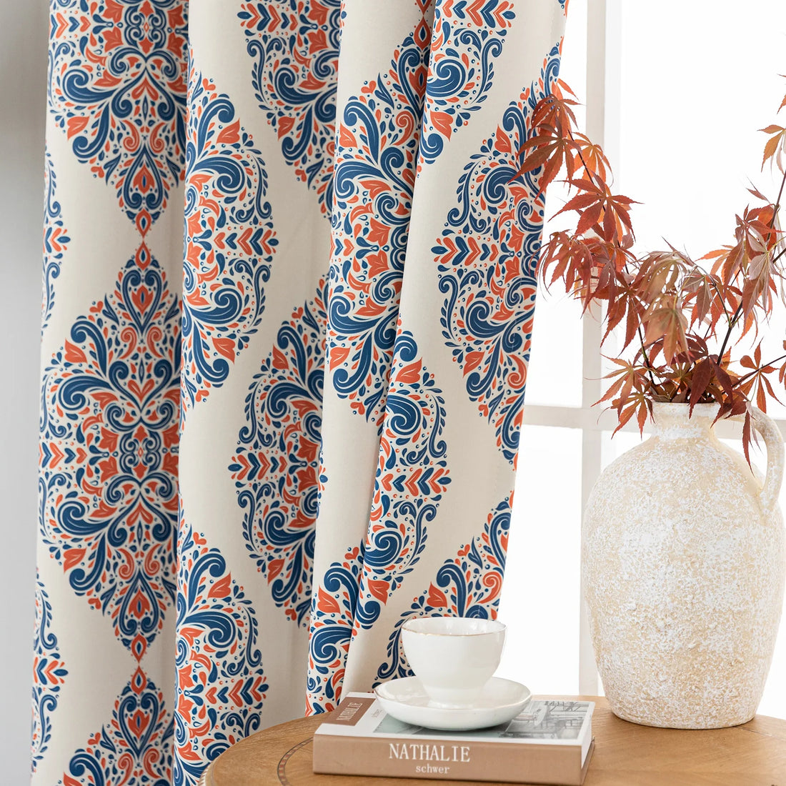 Elegant blackout curtain with blue and orange damask patterns on a cream background, offering stylish light-blocking and privacy for any room.