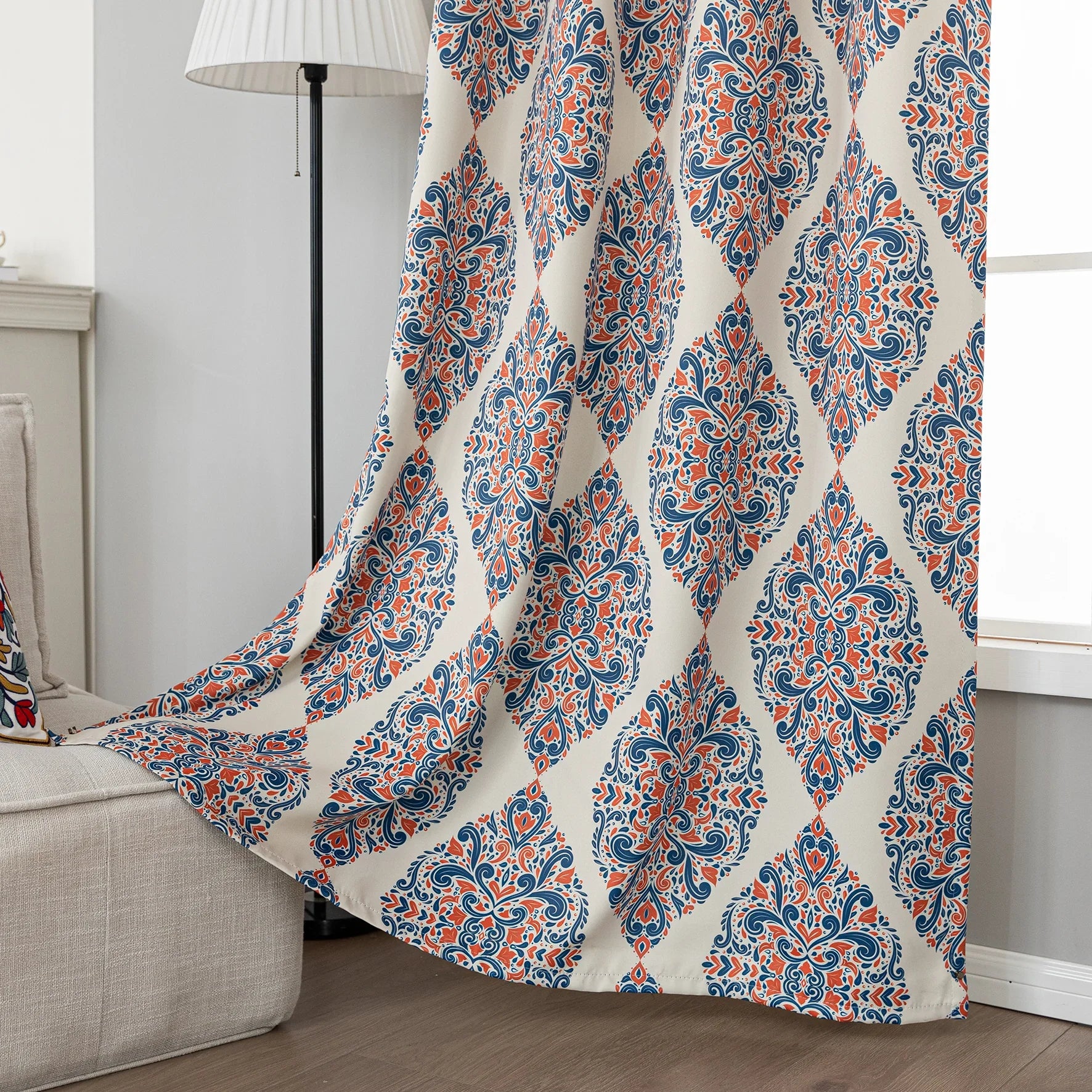 Elegant blackout curtain with blue and orange damask patterns on a cream background, offering stylish light-blocking and privacy for any room.