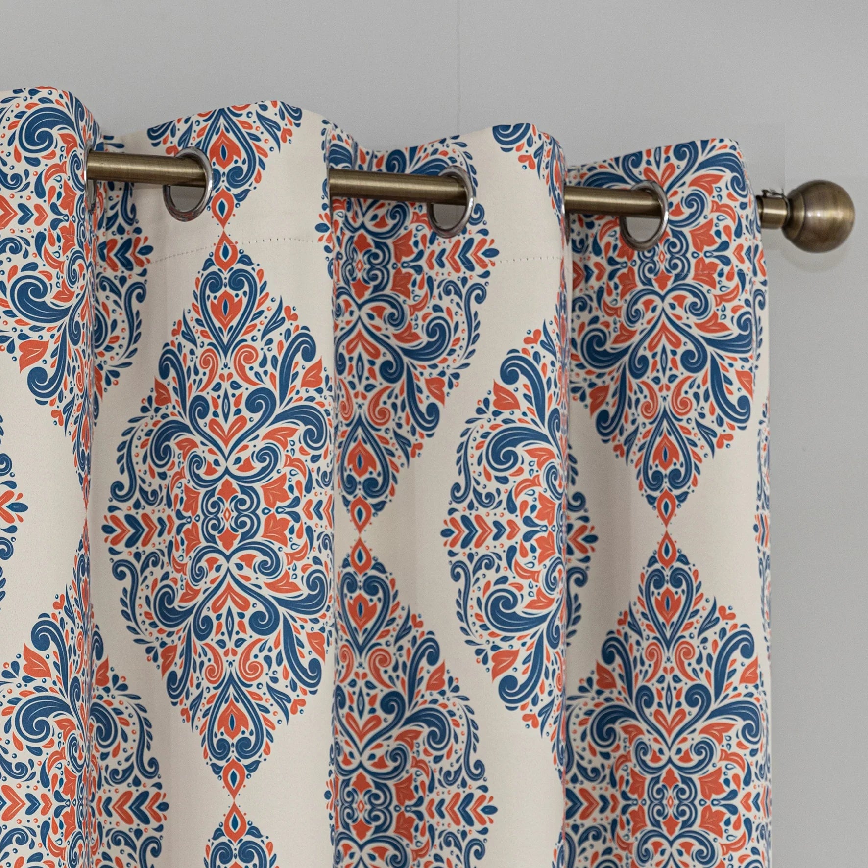 Elegant blackout curtain with blue and orange damask patterns on a cream background, offering stylish light-blocking and privacy for any room.