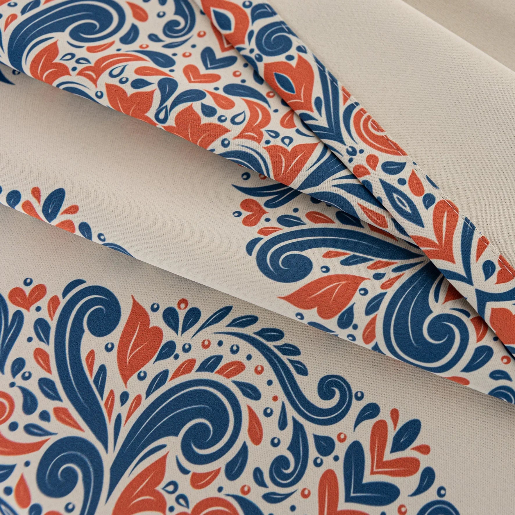 Elegant blackout curtain with blue and orange damask patterns on a cream background, offering stylish light-blocking and privacy for any room.