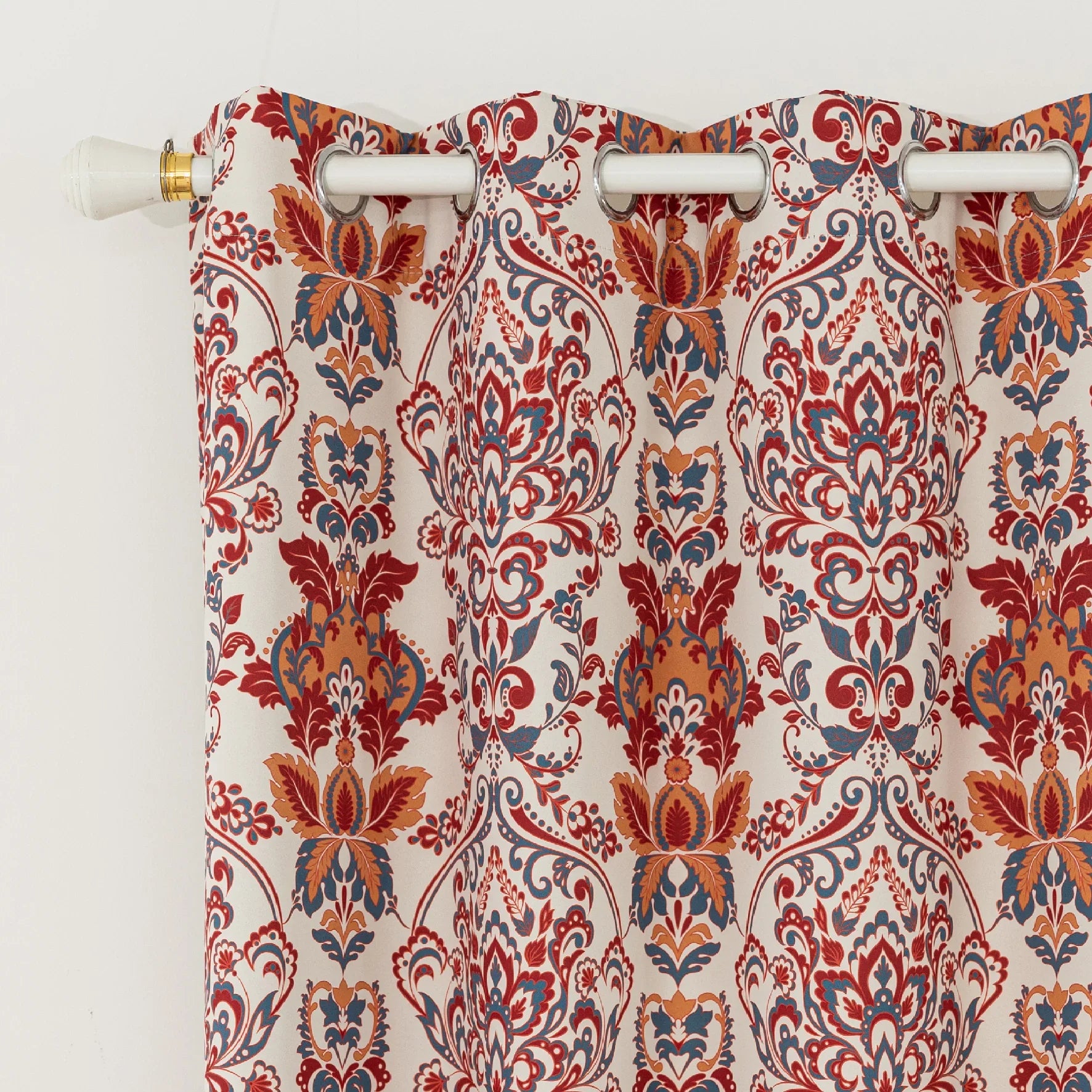 Vibrant blackout curtain featuring an intricate red, orange, and blue damask floral pattern on a soft cream background, designed to block light, enhance privacy, and add a bold, elegant touch to any room décor.