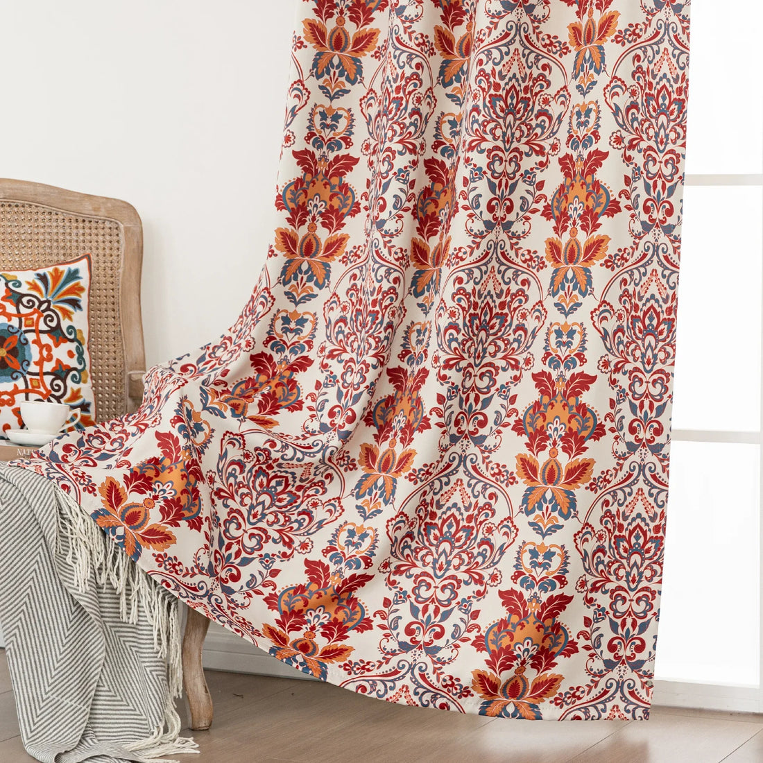 Vibrant blackout curtain featuring an intricate red, orange, and blue damask floral pattern on a soft cream background, designed to block light, enhance privacy, and add a bold, elegant touch to any room décor.