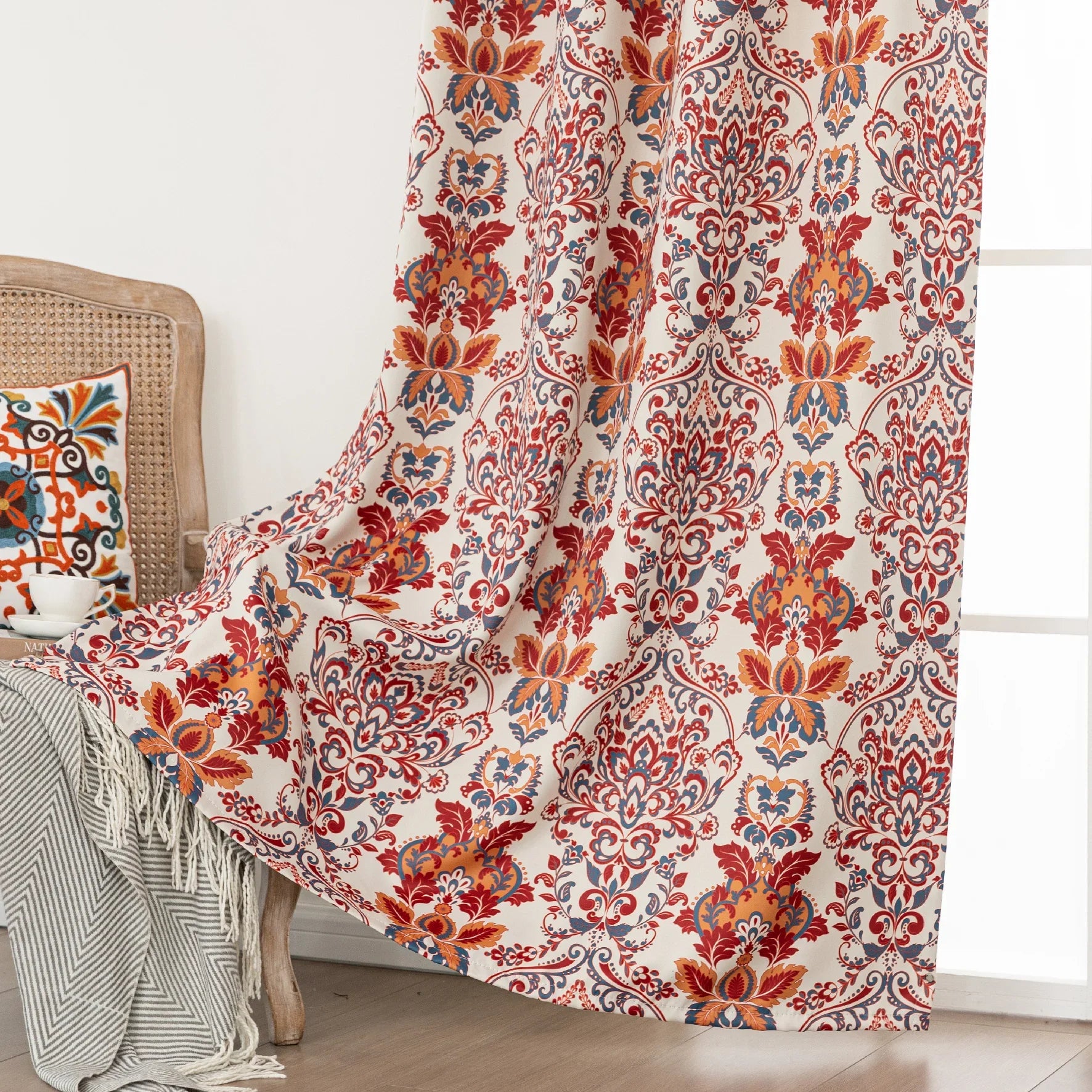 Vibrant blackout curtain featuring an intricate red, orange, and blue damask floral pattern on a soft cream background, designed to block light, enhance privacy, and add a bold, elegant touch to any room décor.