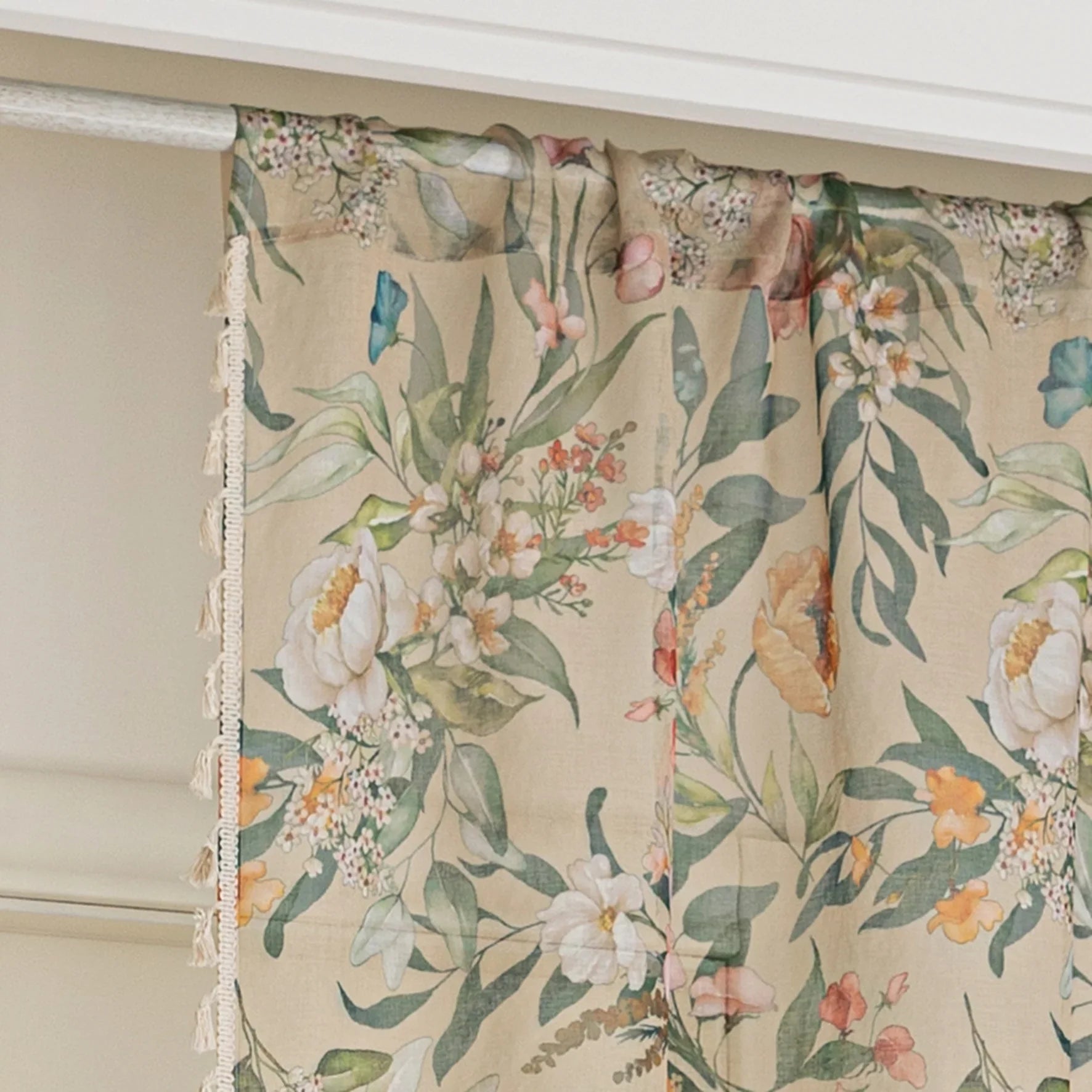 Beige floral curtain with colorful botanical patterns in green, orange, pink, and white, featuring elegant tassel trim on the edge, ideal for adding a fresh, nature-inspired touch to home décor.
