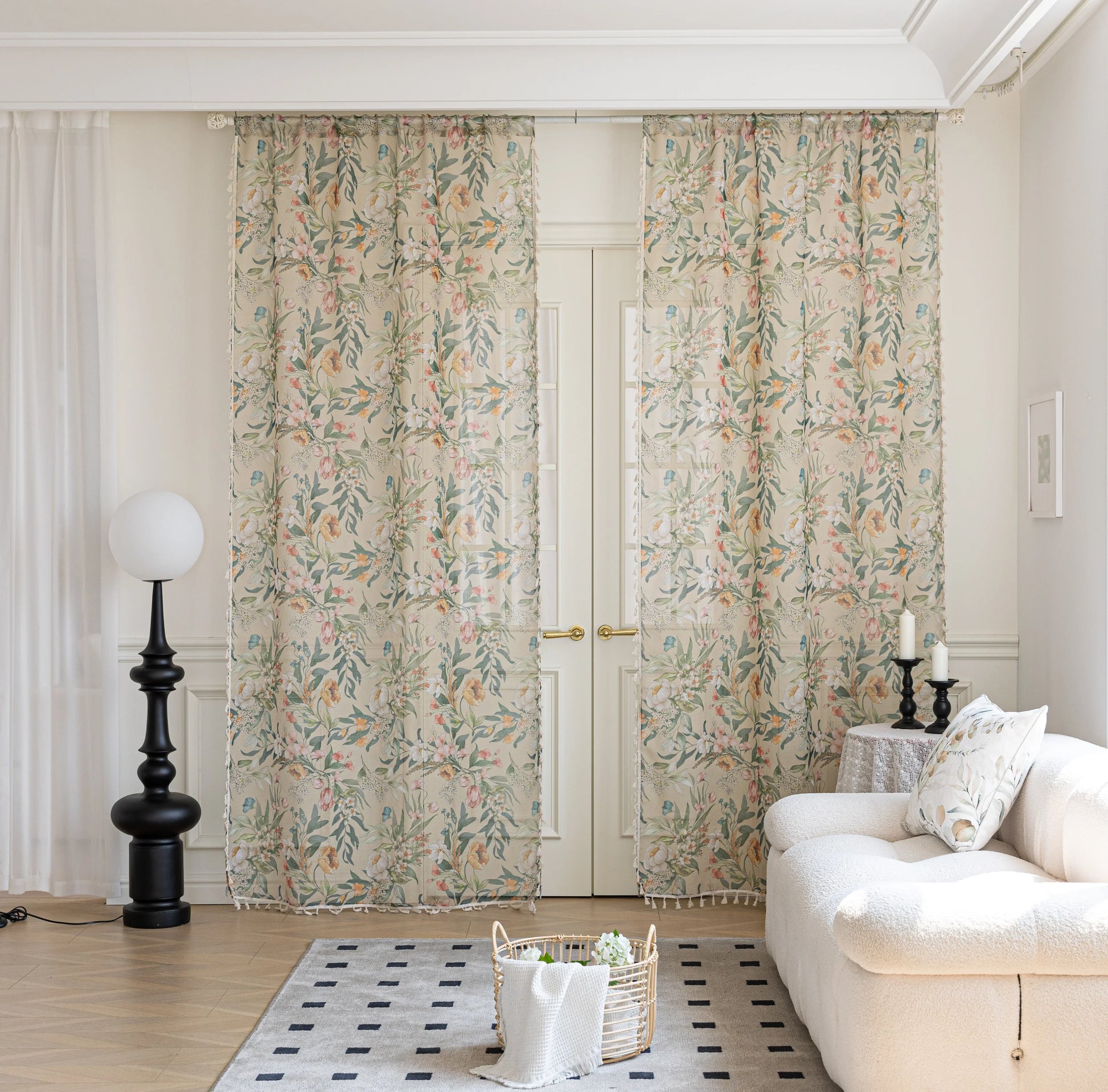 Sheer beige curtains with colorful floral and leaf print, adding a light and airy botanical touch to a bright, cozy living room décor.