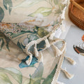 Close-up of beige sheer curtain with colorful floral and leafy pattern, decorated with delicate tassel trim, creating an elegant and airy botanical look for home interiors.