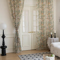 Close-up of beige sheer curtain with colorful floral and leafy pattern, decorated with delicate tassel trim, creating an elegant and airy botanical look for home interiors.