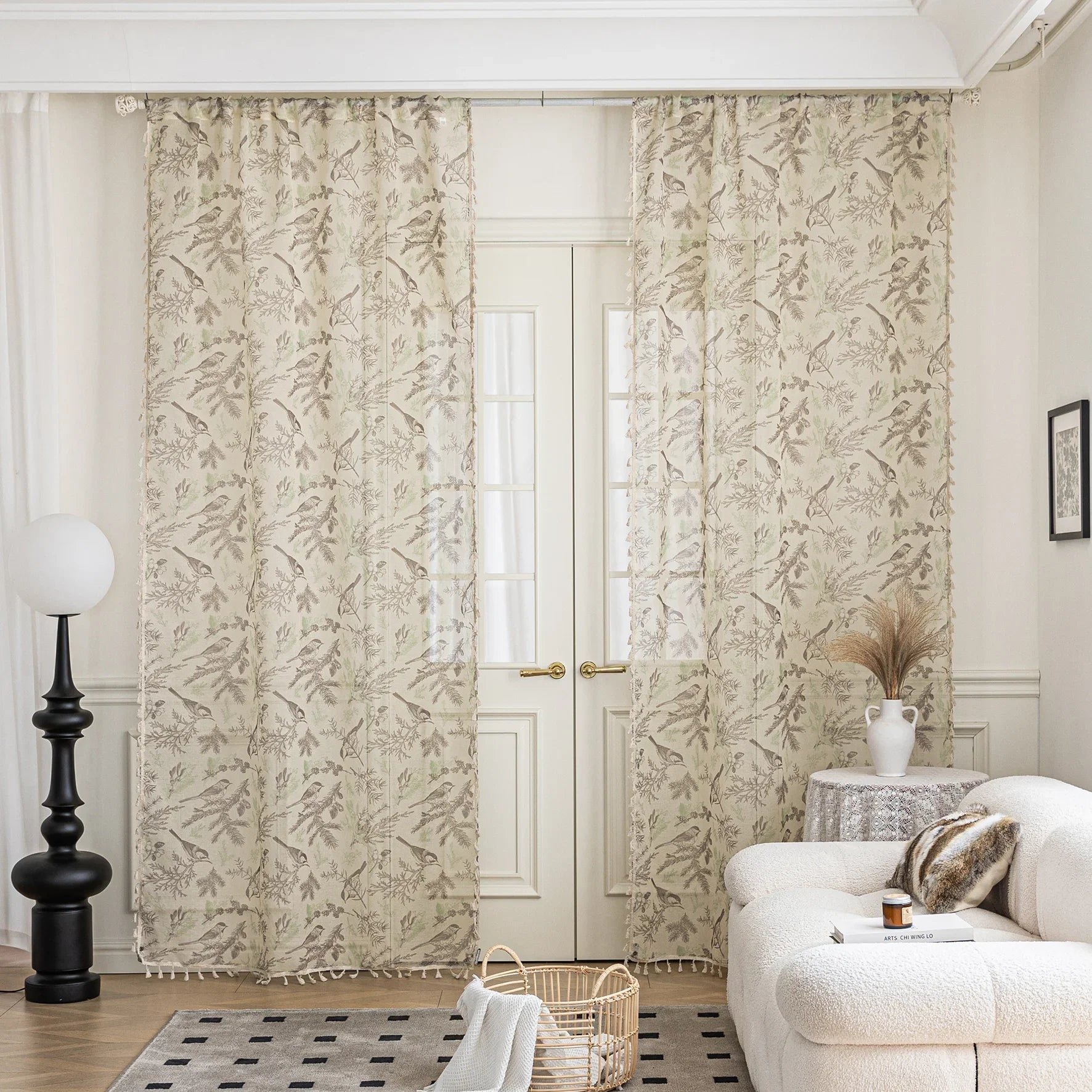 Sheer beige curtains with delicate bird and botanical print in soft brown and green hues, creating an airy, nature-inspired look for French doors in a cozy living room.