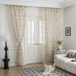 beige linen curtain fabric with brown and green botanical and bird print, featuring decorative tassel trim