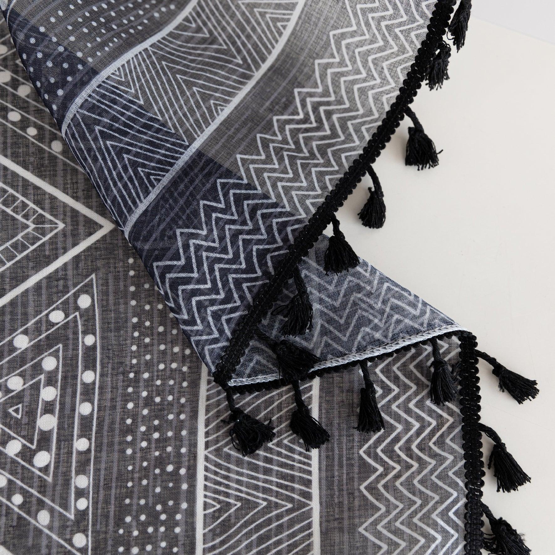 Modern Black and White Geometric Sheer Curtains – Enhance your home with these contemporary sheer curtains featuring an intricate tribal-inspired geometric pattern in black and white. The lightweight fabric allows natural light to filter through while maintaining a sense of privacy, making them perfect for living rooms, bedrooms, or minimalist interiors. Finished with delicate black tassels along the edges, these curtains add a stylish yet subtle decorative touch that complements modern, boho, or Scandinavi
