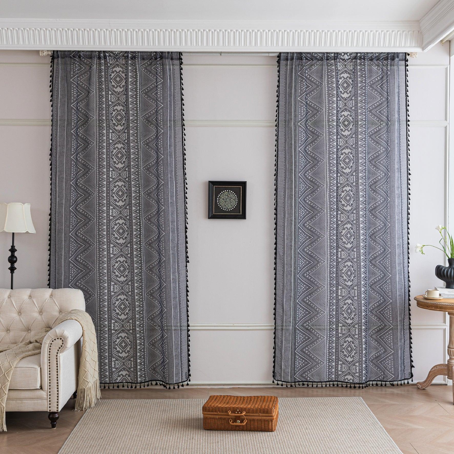Modern Black and White Geometric Sheer Curtains – Enhance your home with these contemporary sheer curtains featuring an intricate tribal-inspired geometric pattern in black and white. The lightweight fabric allows natural light to filter through while maintaining a sense of privacy, making them perfect for living rooms, bedrooms, or minimalist interiors. Finished with delicate black tassels along the edges, these curtains add a stylish yet subtle decorative touch that complements modern, boho, or Scandinavi