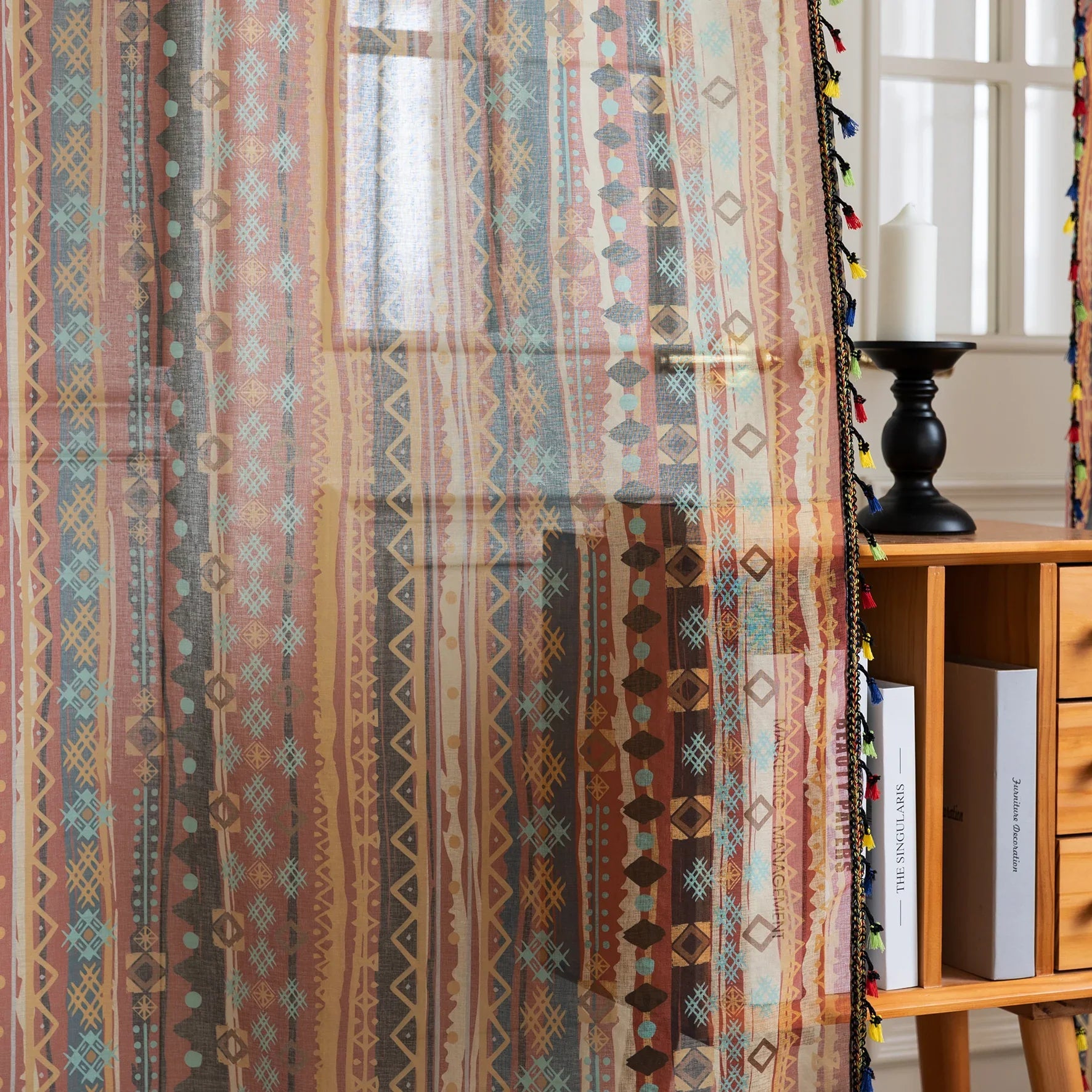 Bring warmth and character to your space with this bohemian tribal-patterned sheer curtain, featuring rich earth tones, geometric motifs, and colorful tassel trim. Crafted from lightweight, breathable fabric, it softly filters sunlight to create a cozy and inviting ambiance while maintaining privacy.