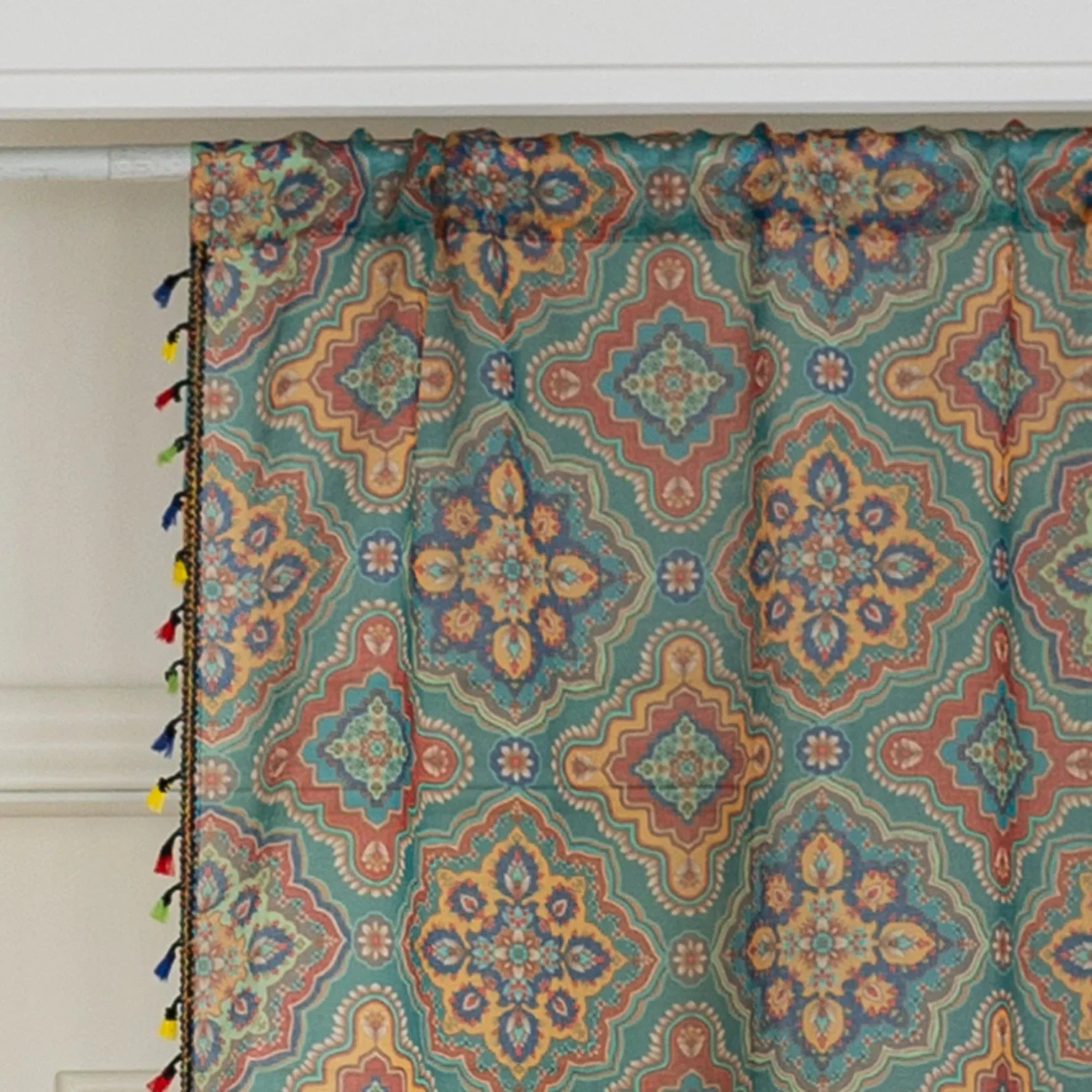 Bring vibrant elegance to your home with this bohemian-style sheer curtain, featuring an intricate geometric pattern in rich teal, orange, and gold tones. Crafted from lightweight, breathable fabric, it allows natural light to filter through while maintaining privacy. Perfect for living rooms, bedrooms, or creative spaces, this decorative curtain adds warmth and personality to any interior. The colorful tassel trim enhances its artisanal charm, making it a versatile choice for both modern and eclectic home 