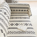 Modern black and white geometric patterned sofa cover with tribal-inspired diamond and stripe designs.