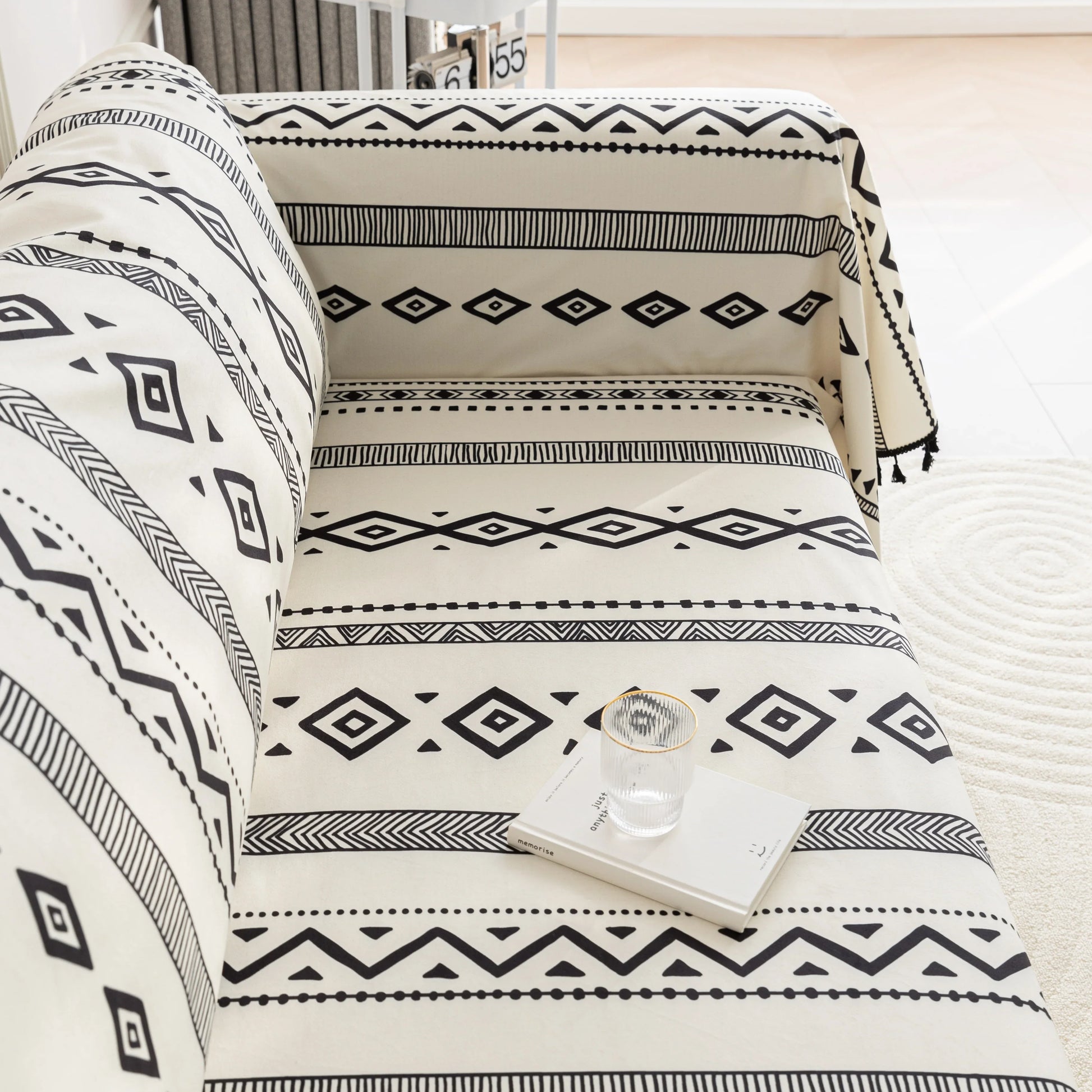 Modern black and white geometric patterned sofa cover with tribal-inspired diamond and stripe designs.