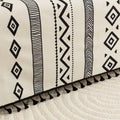 Modern black and white geometric patterned sofa cover with tribal-inspired diamond and stripe designs.