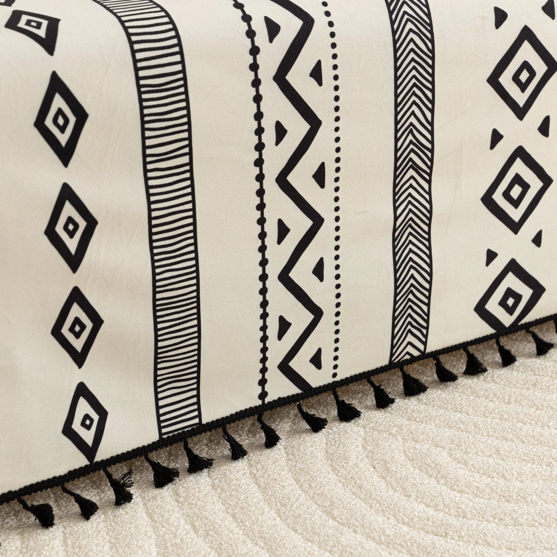 Modern black and white geometric patterned sofa cover with tribal-inspired diamond and stripe designs.