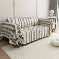 Modern black and white geometric patterned sofa cover with tribal-inspired diamond and stripe designs.