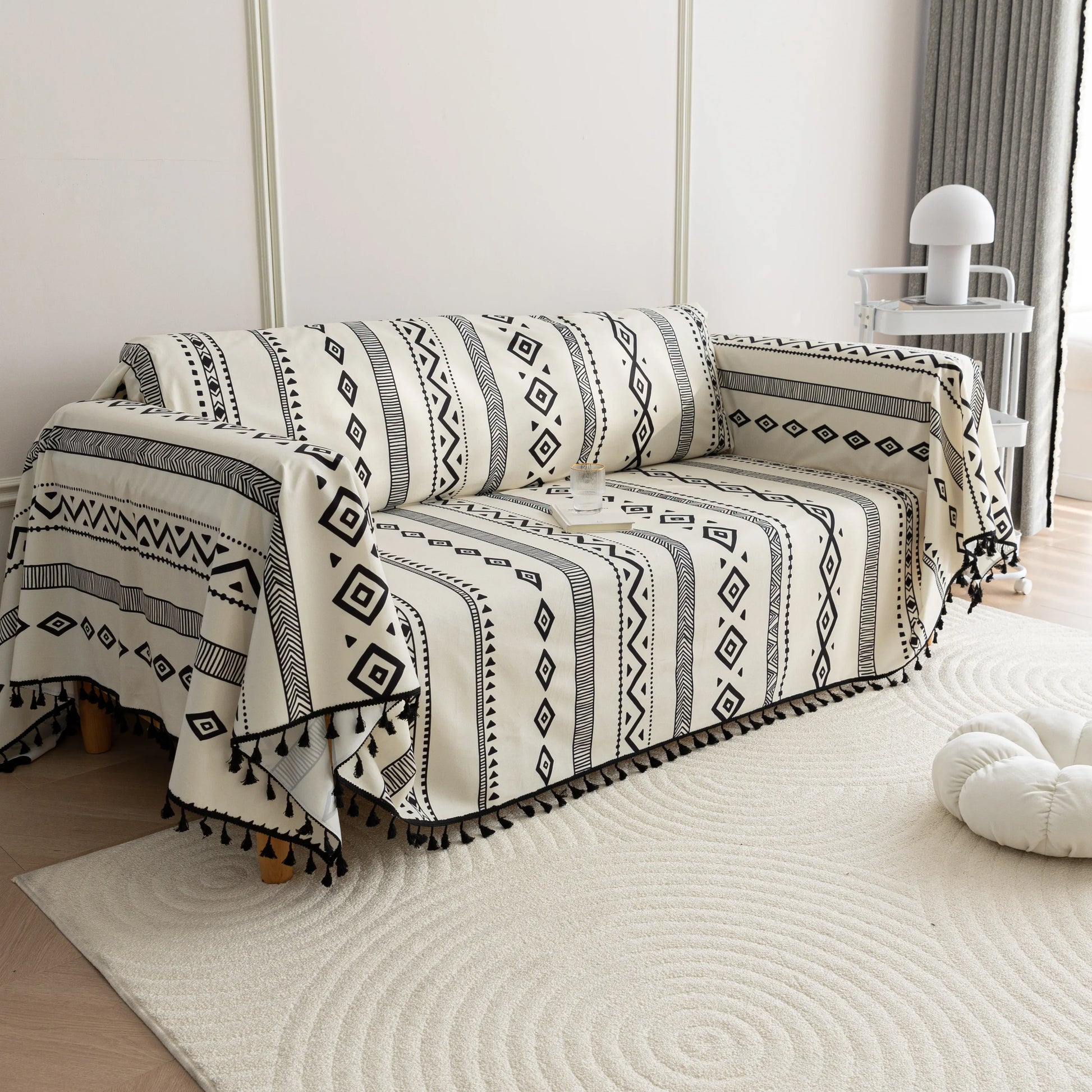 Modern black and white geometric patterned sofa cover with tribal-inspired diamond and stripe designs.